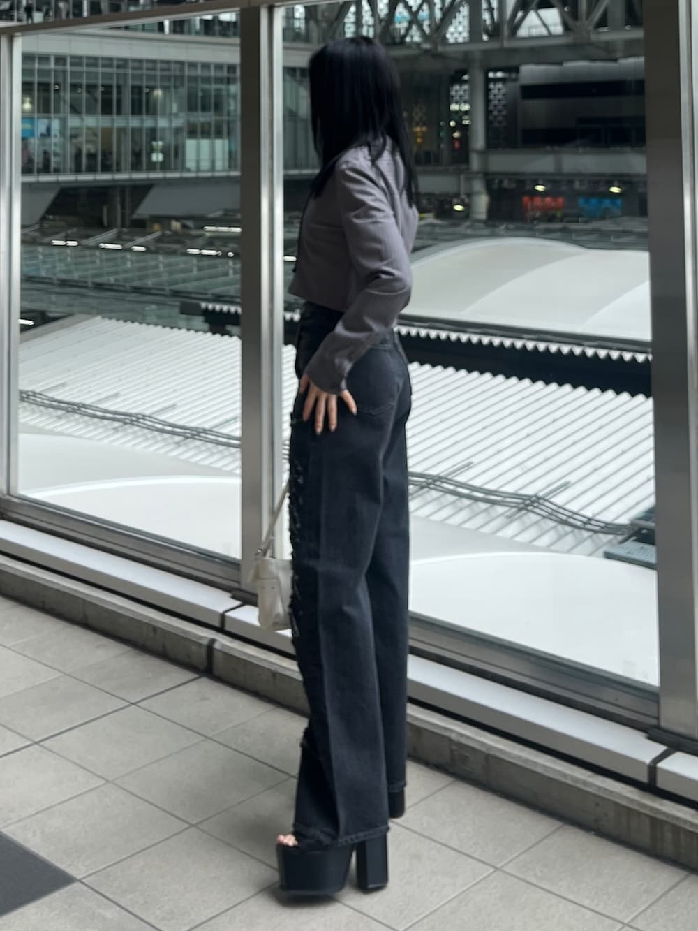 グレー系のシャツ/ブラウス、ブラック系のデニムパンツ、ブラック系のサンダルを着用したレディースの春コーディネートの2枚目の写真