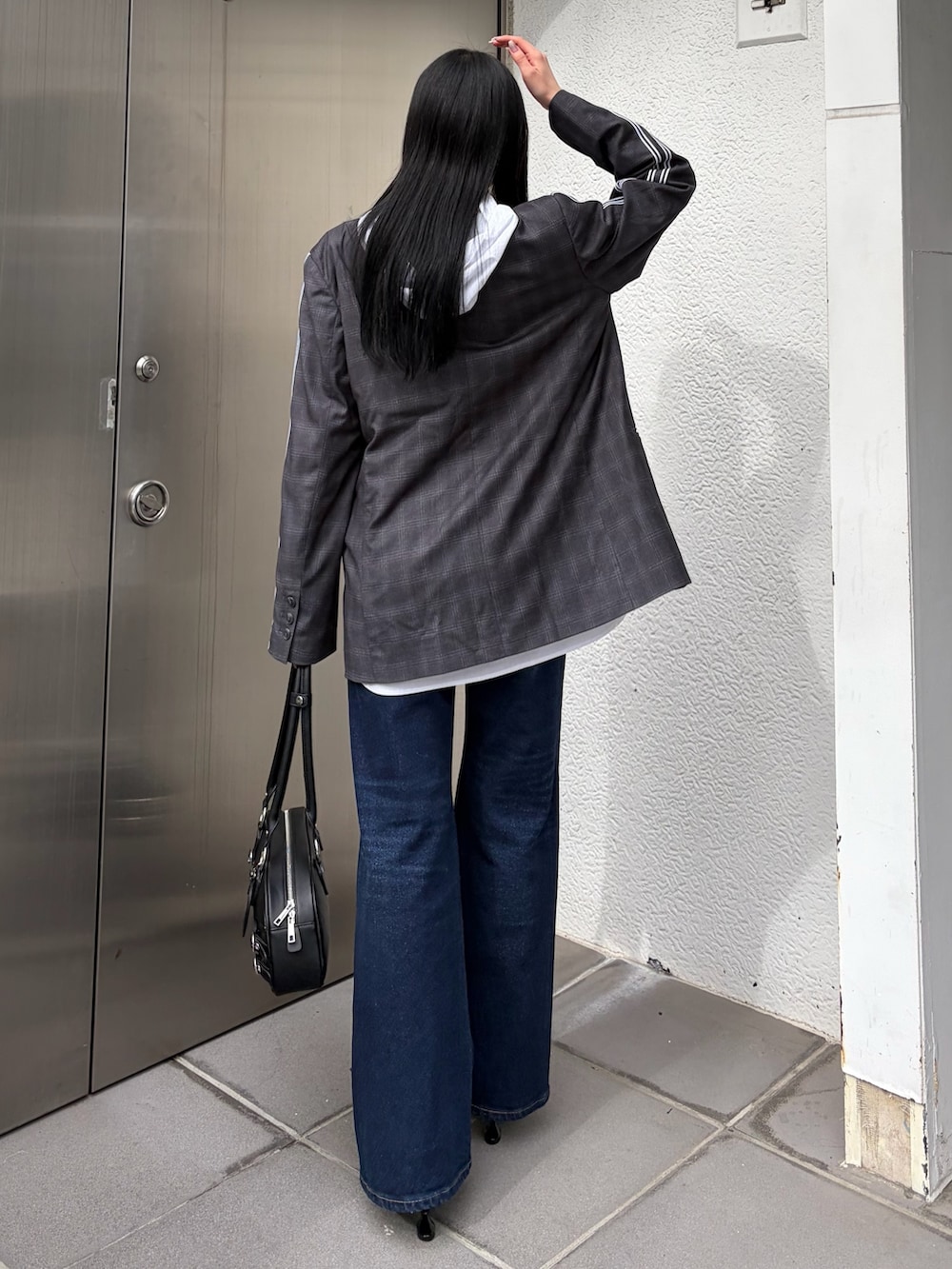 グレー系のテーラードジャケット、ホワイト系のシャツ/ブラウス、ブルー系のデニムパンツを着用したレディースの春コーディネートの5枚目の写真