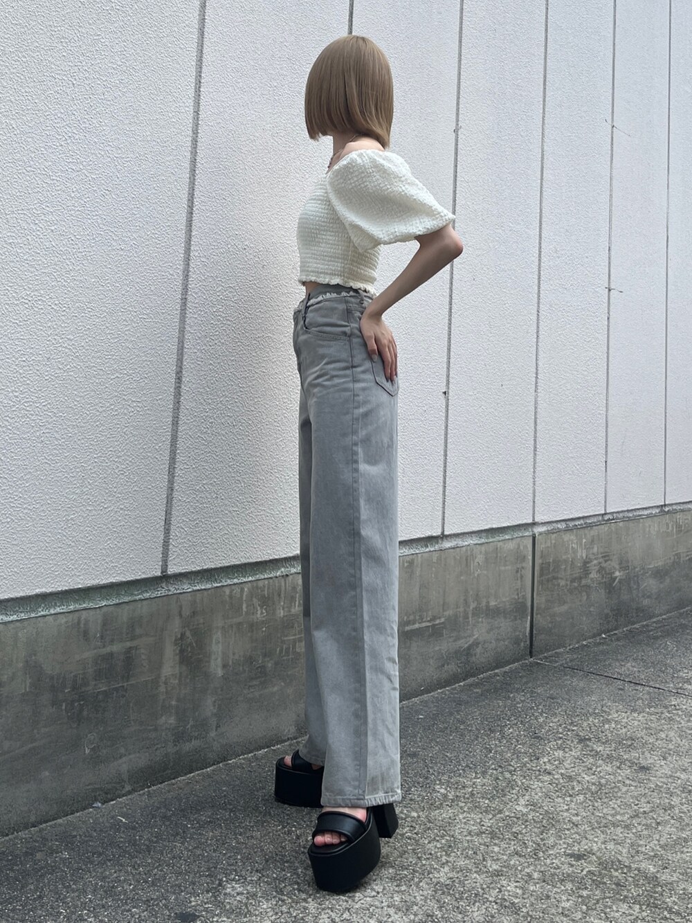 ホワイト系のTシャツ/カットソー、グレー系のデニムパンツ、ブラック系のサンダルを着用したレディースの夏コーディネートの2枚目の写真