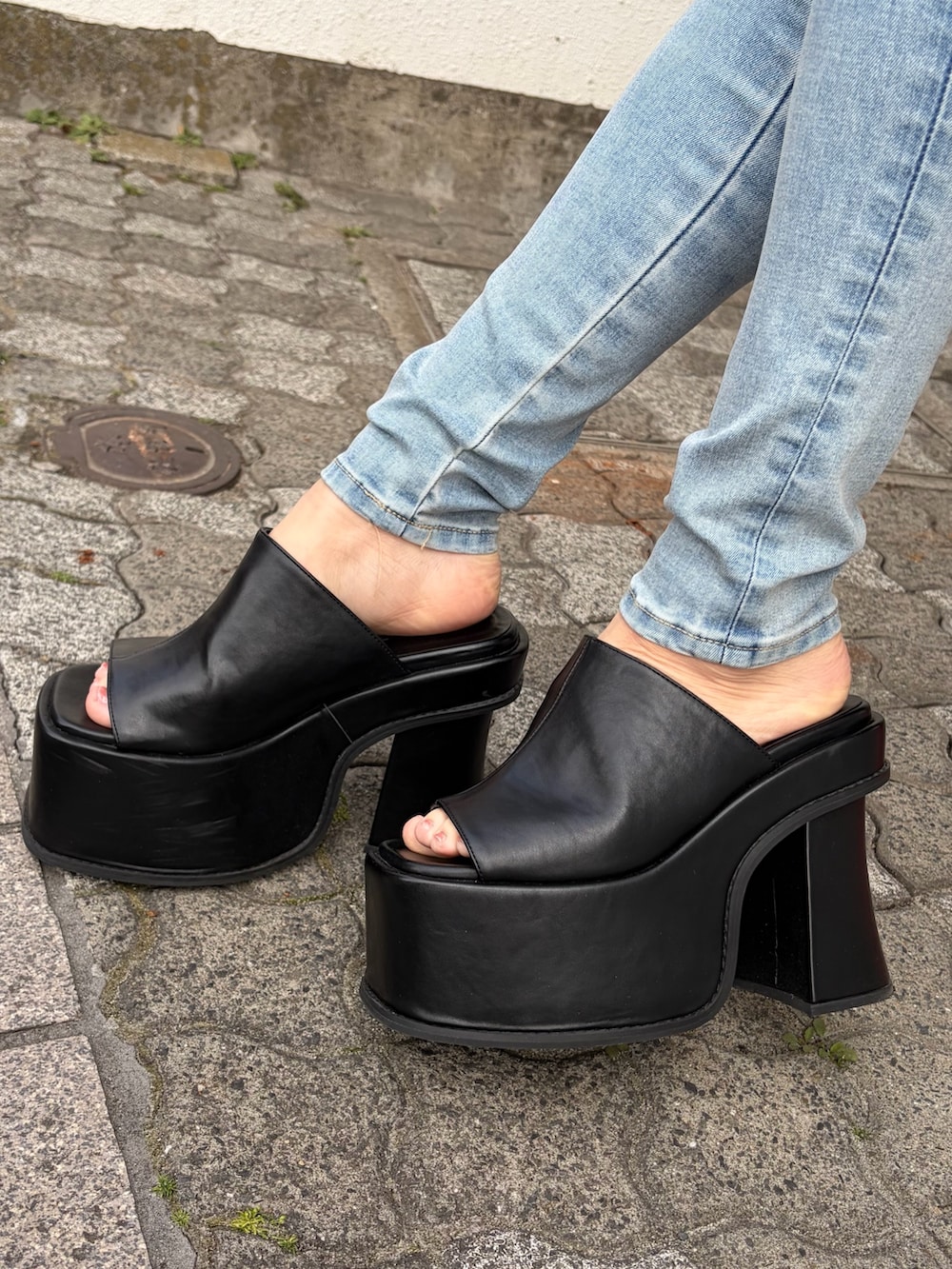 ブラック系のハンドバッグ、ブルー系のサロペット/オーバーオール、ブルー系のTシャツ/カットソーを着用したレディースの春コーディネートの6枚目の写真