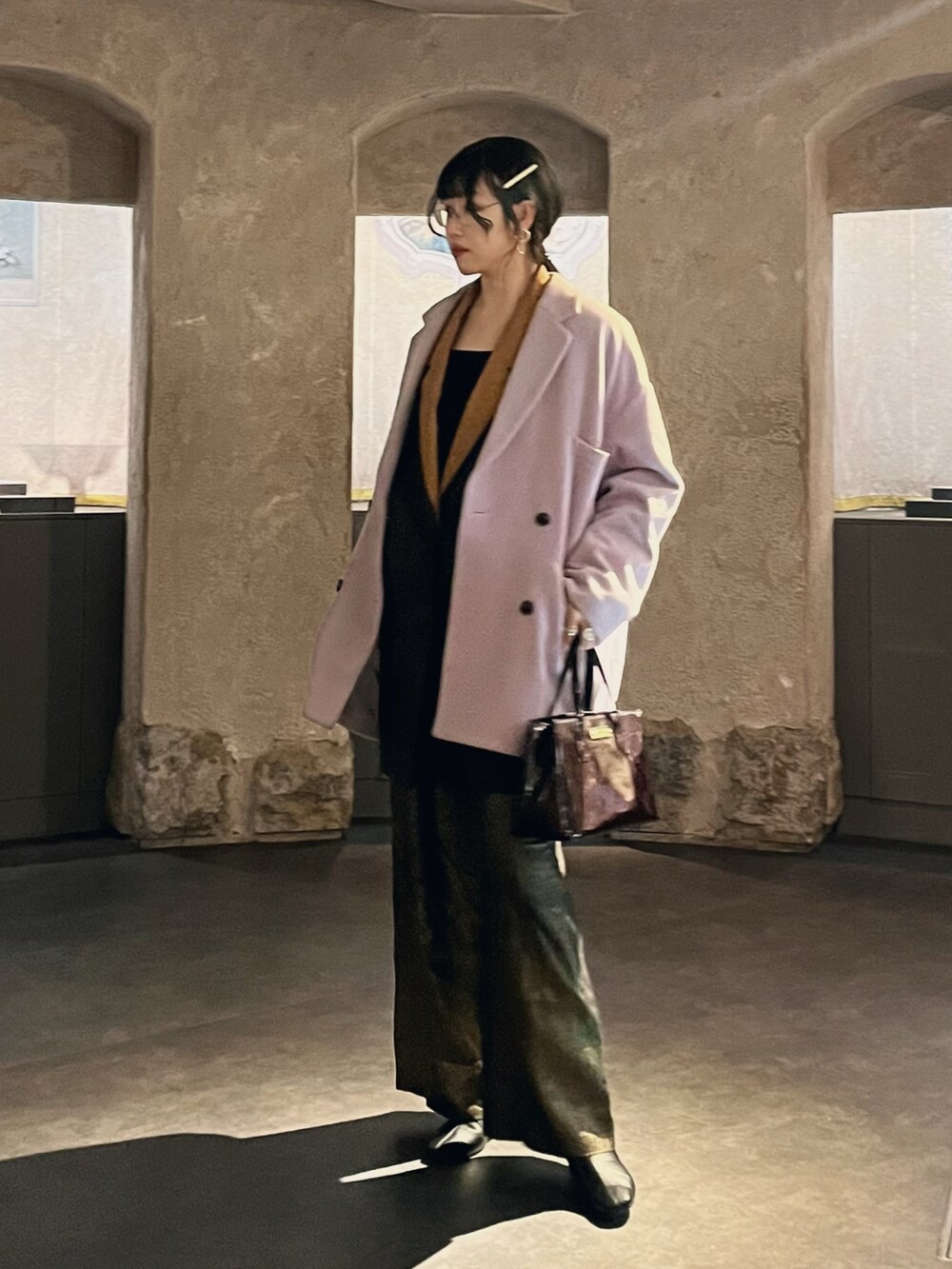 ブラウン系のハンドバッグ、ブラック系のブーツ、その他のその他パンツを着用したレディースの冬コーディネートの2枚目の写真