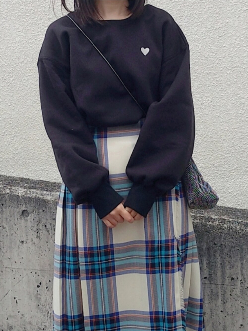 ホワイト系のスカート、ブラック系のショルダーバッグ、ブラック系のスウェットを着用したレディースの秋コーディネートの2枚目の写真