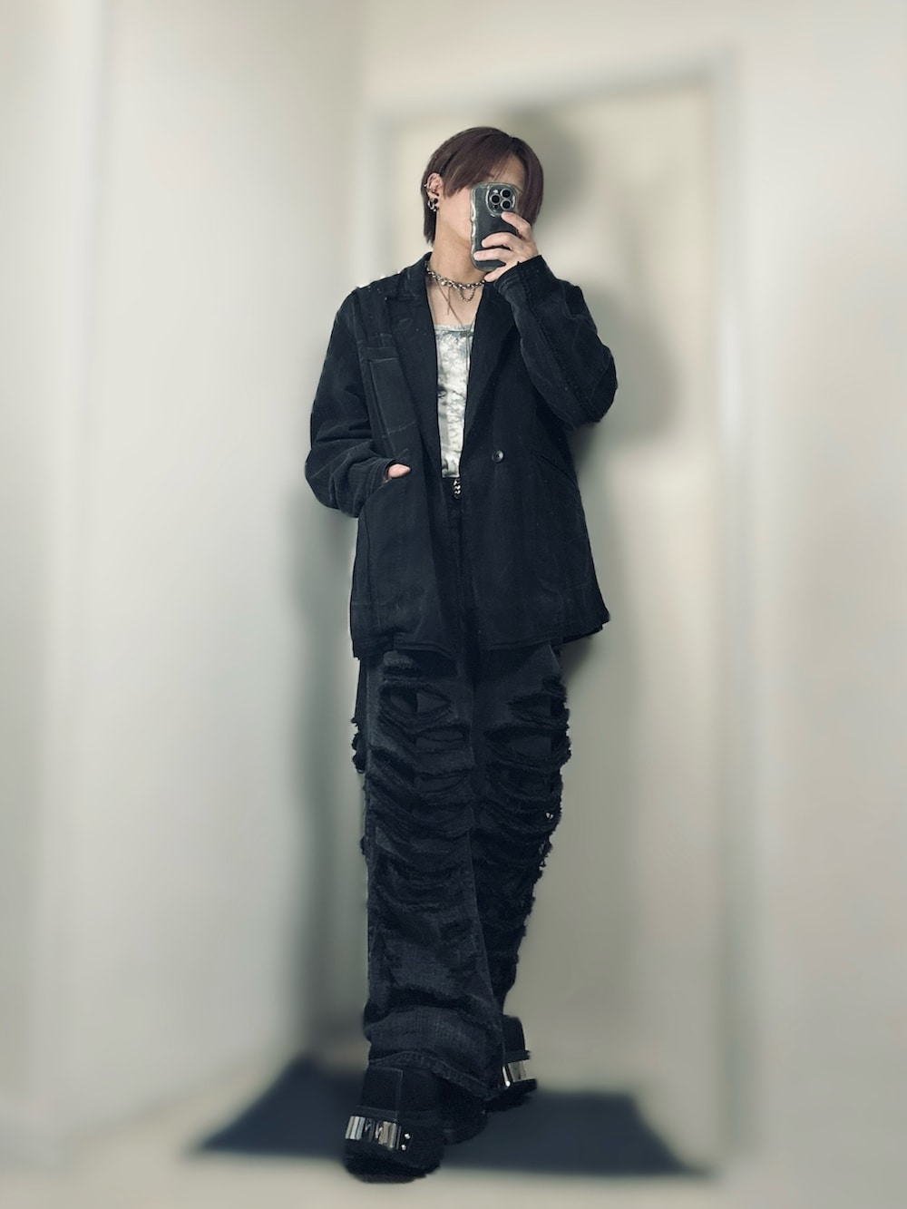 ブラック系のテーラードジャケット、ホワイト系のTシャツ/カットソー、ブラック系のデニムパンツを着用したメンズの春コーディネートの3枚目の写真