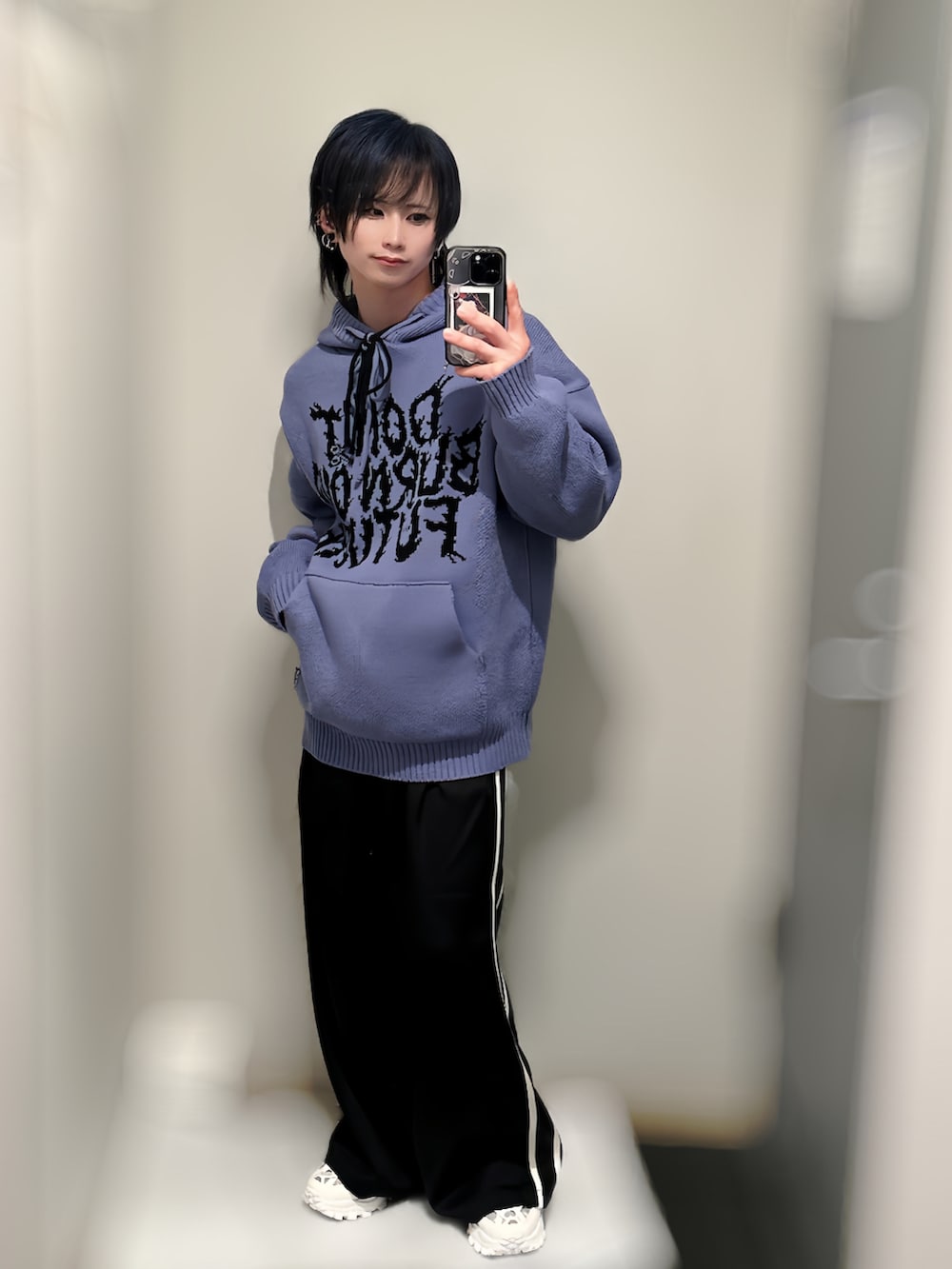 パープル系のニット/セーター、ブラック系のその他パンツ、ホワイト系のスニーカーを着用したメンズの冬コーディネートの2枚目の写真