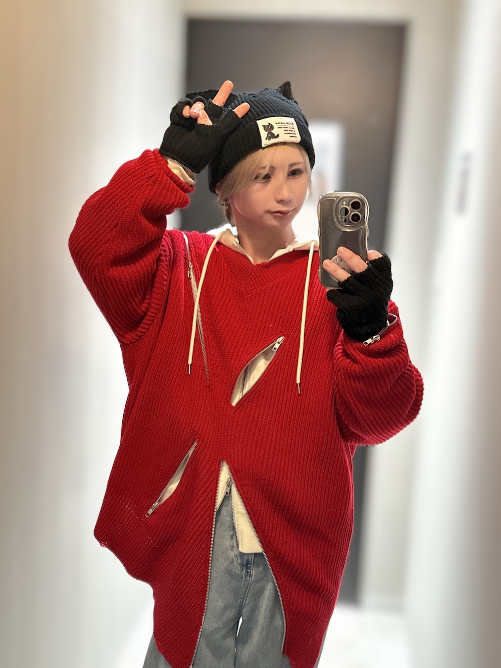 ブルー系のデニムパンツ、ホワイト系のスニーカー、レッド系のニット/セーターを着用したメンズの冬コーディネートの3枚目の写真