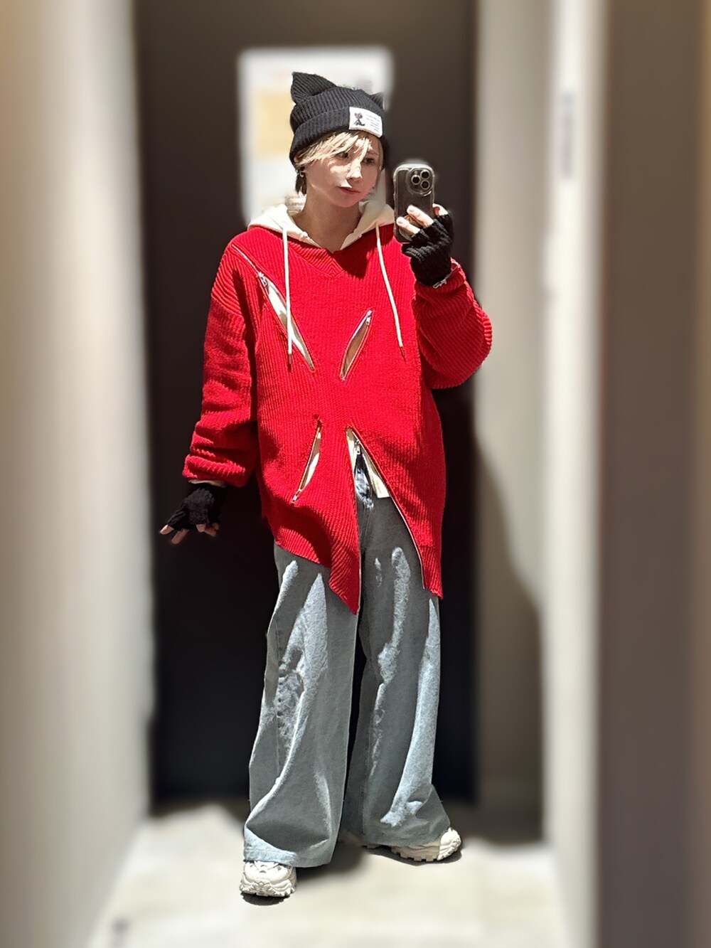 ブルー系のデニムパンツ、ホワイト系のスニーカー、レッド系のニット/セーターを着用したメンズの冬コーディネートの2枚目の写真