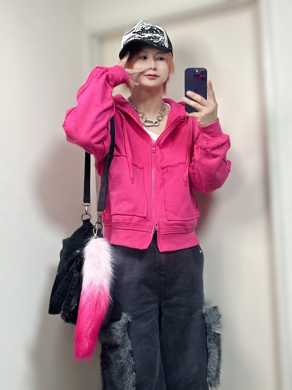 ピンク系のパーカー、ブラック系のデニムパンツ、ブラック系のスニーカーを着用したメンズの夏コーディネートの3枚目の写真