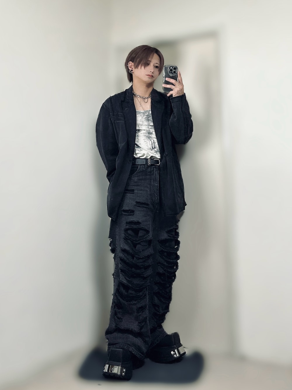 ブラック系のテーラードジャケット、ホワイト系のTシャツ/カットソー、ブラック系のデニムパンツを着用したメンズの春コーディネートの2枚目の写真