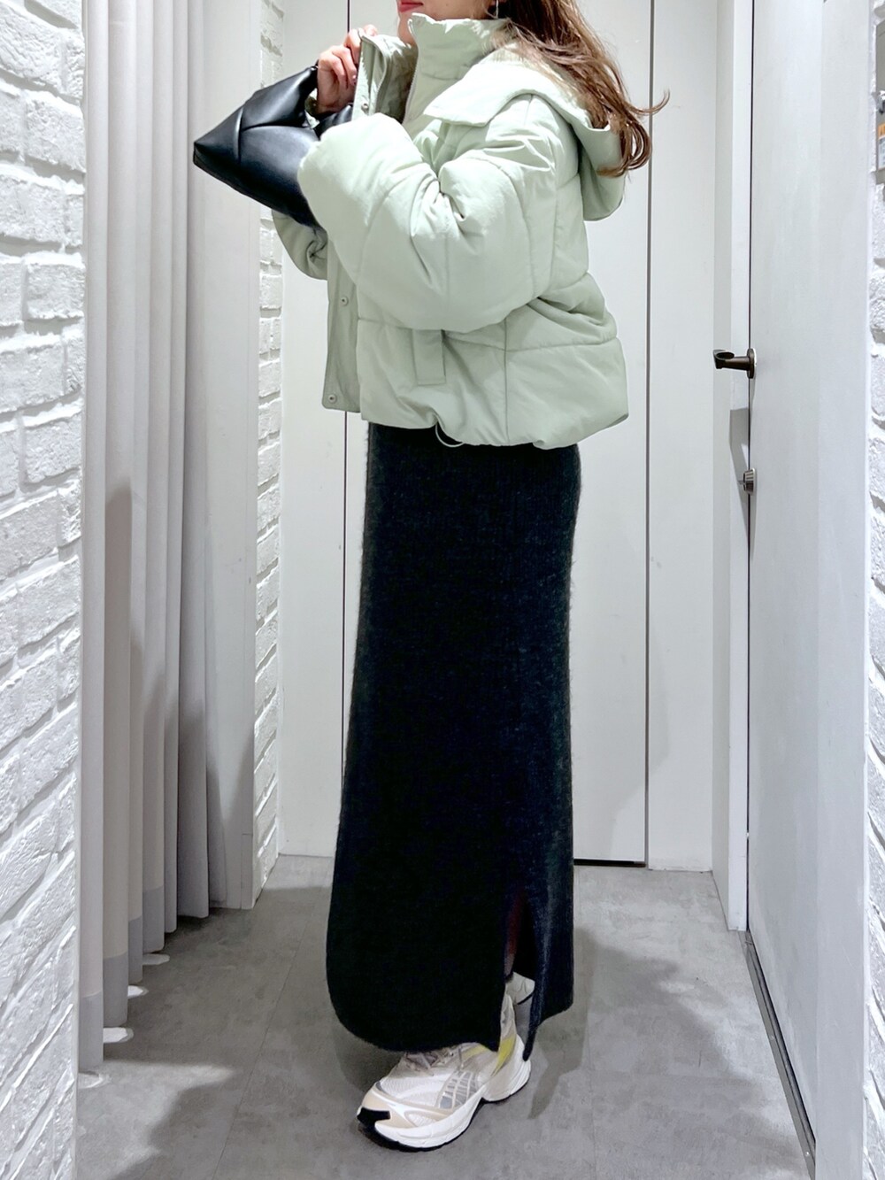 ブラック系のワンピース、グリーン系のブルゾン、ブラック系のショルダーバッグを着用したレディースの冬コーディネートの5枚目の写真