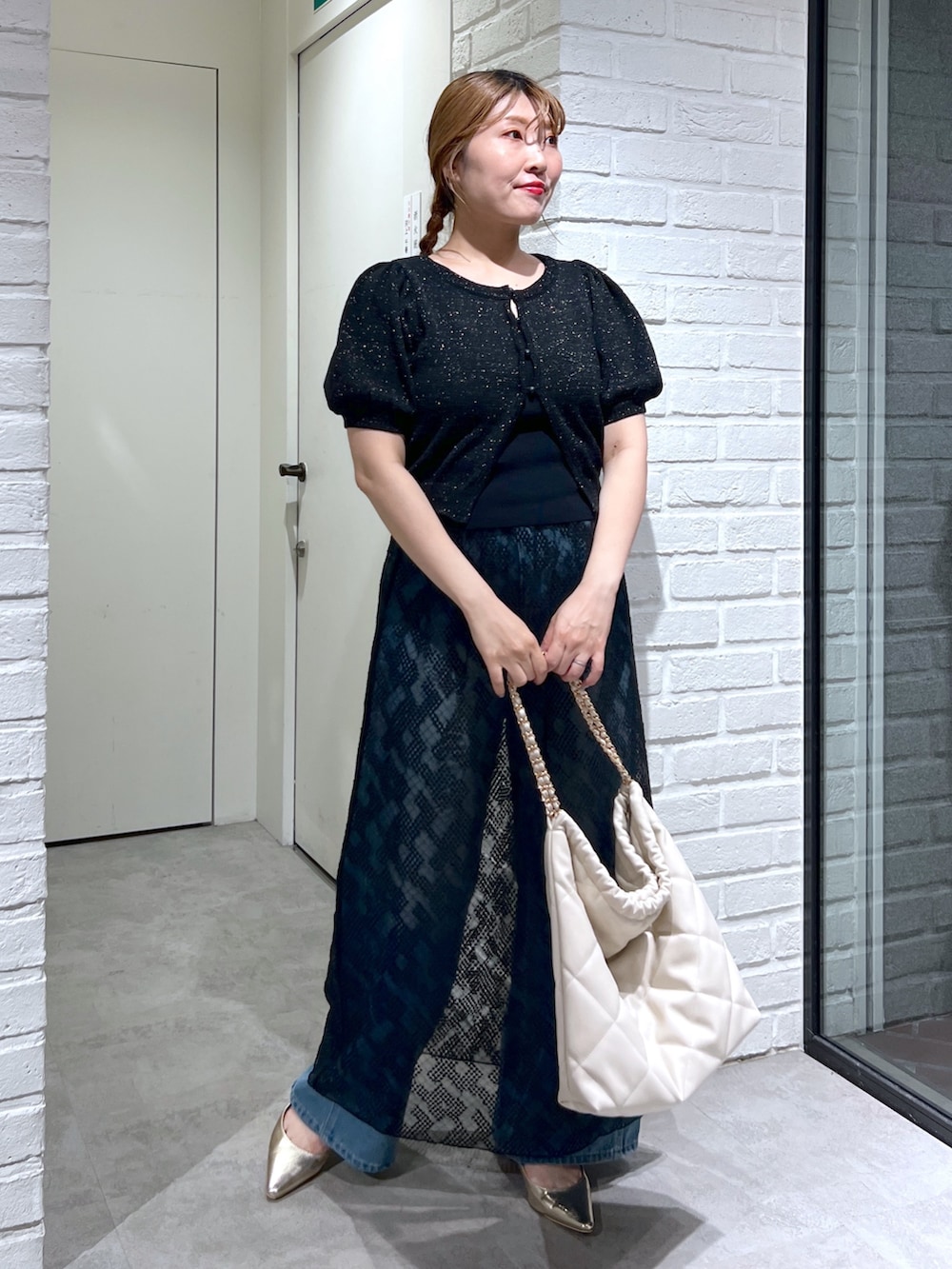 ブラック系のスカート、ブルー系のデニムパンツ、ブラック系のカーディガン/ボレロを着用したレディースの夏コーディネートの2枚目の写真