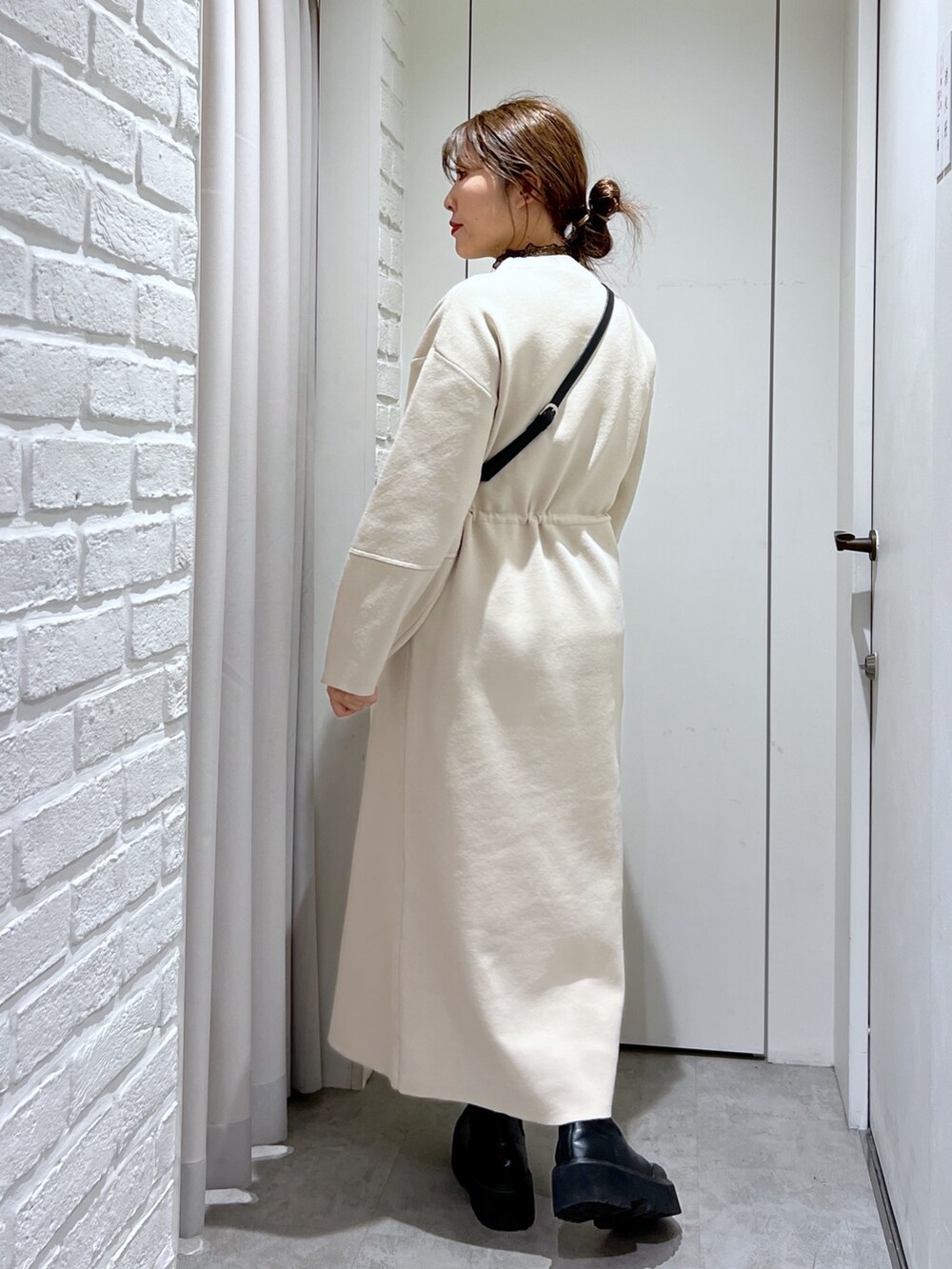 ホワイト系のワンピース、ブラック系のショルダーバッグ、ブラック系のTシャツ/カットソーを着用したレディースの冬コーディネートの4枚目の写真