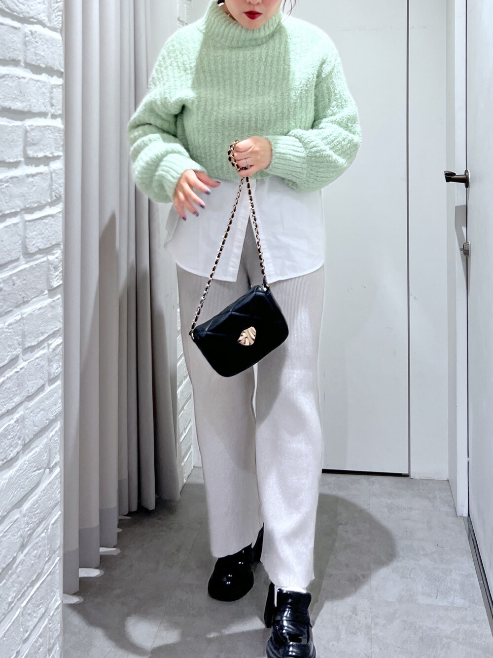 ホワイト系のシャツ/ブラウス、ホワイト系のその他パンツ、グリーン系のニット/セーターを着用したレディースの冬コーディネートの4枚目の写真