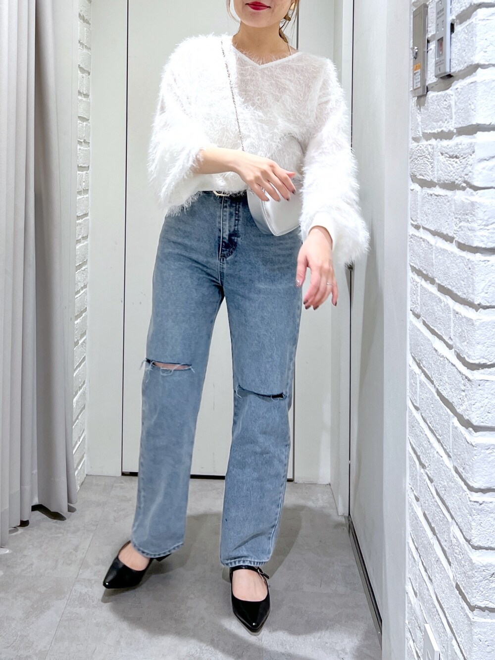 ブルー系のデニムパンツ、ホワイト系のシャツ/ブラウス、シルバー系のショルダーバッグを着用したレディースの春コーディネートの5枚目の写真