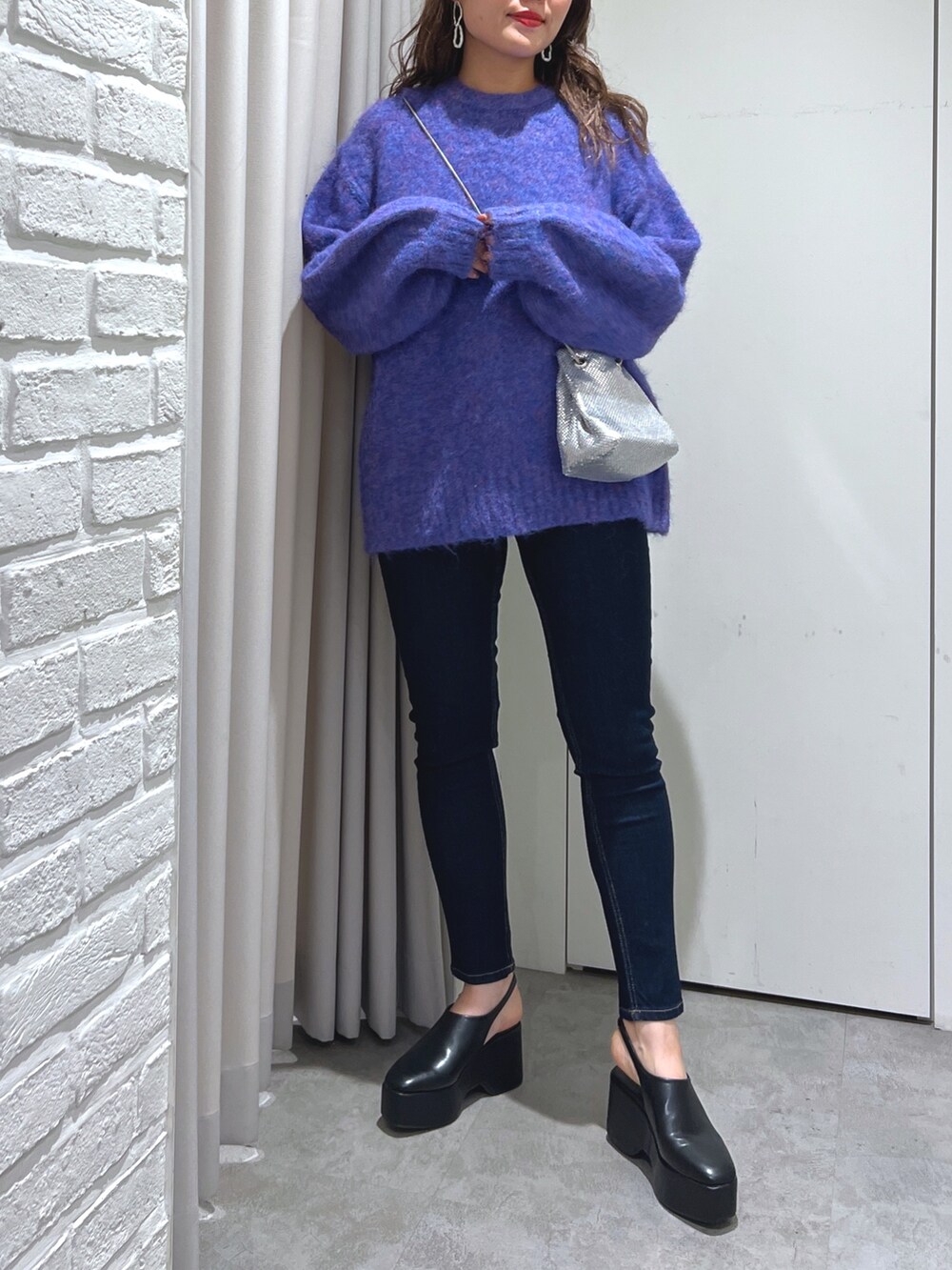 ブルー系のニット/セーター、ブルー系のデニムパンツ、ブラック系のサンダルを着用したレディースの秋コーディネートの3枚目の写真