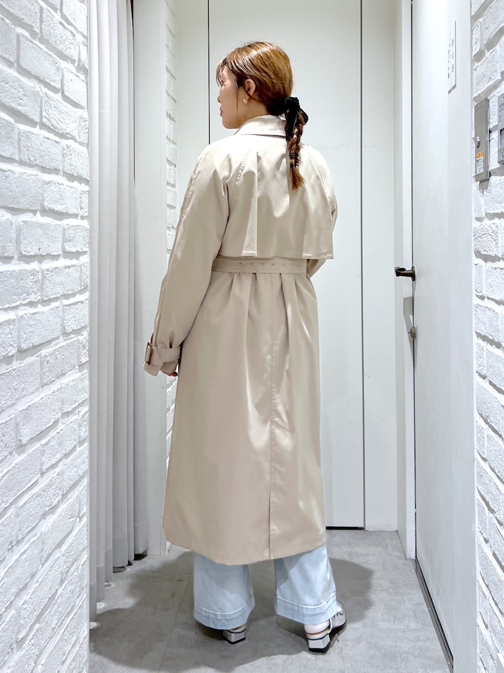 ベージュ系のトレンチコート、ブラック系のショルダーバッグ、ブルー系のデニムパンツを着用したレディースの春コーディネートの5枚目の写真