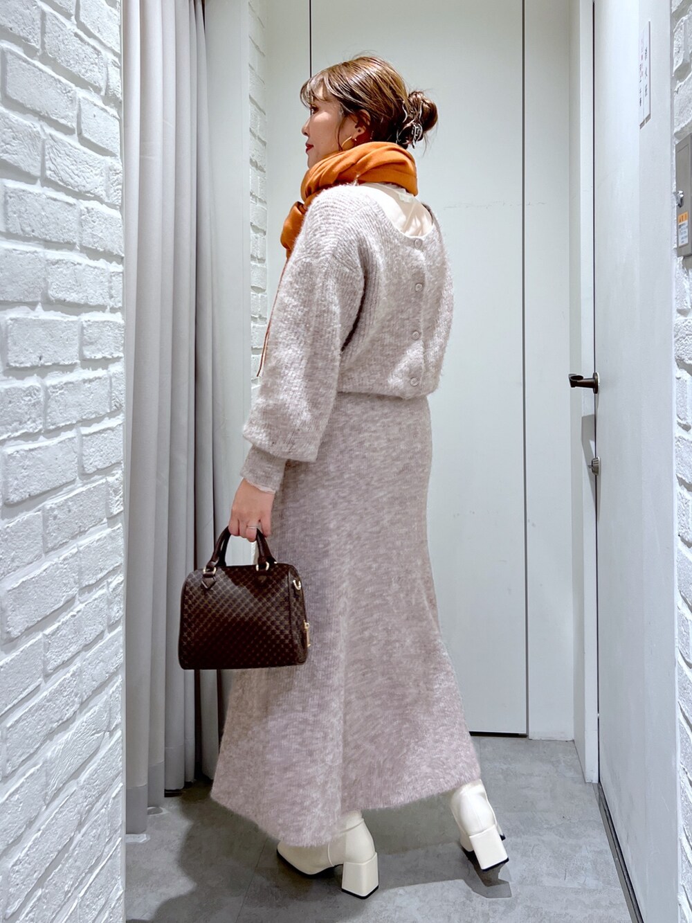ベージュ系のスカート、ベージュ系のニット/セーター、ベージュ系のバッグを着用したレディースの冬コーディネートの4枚目の写真