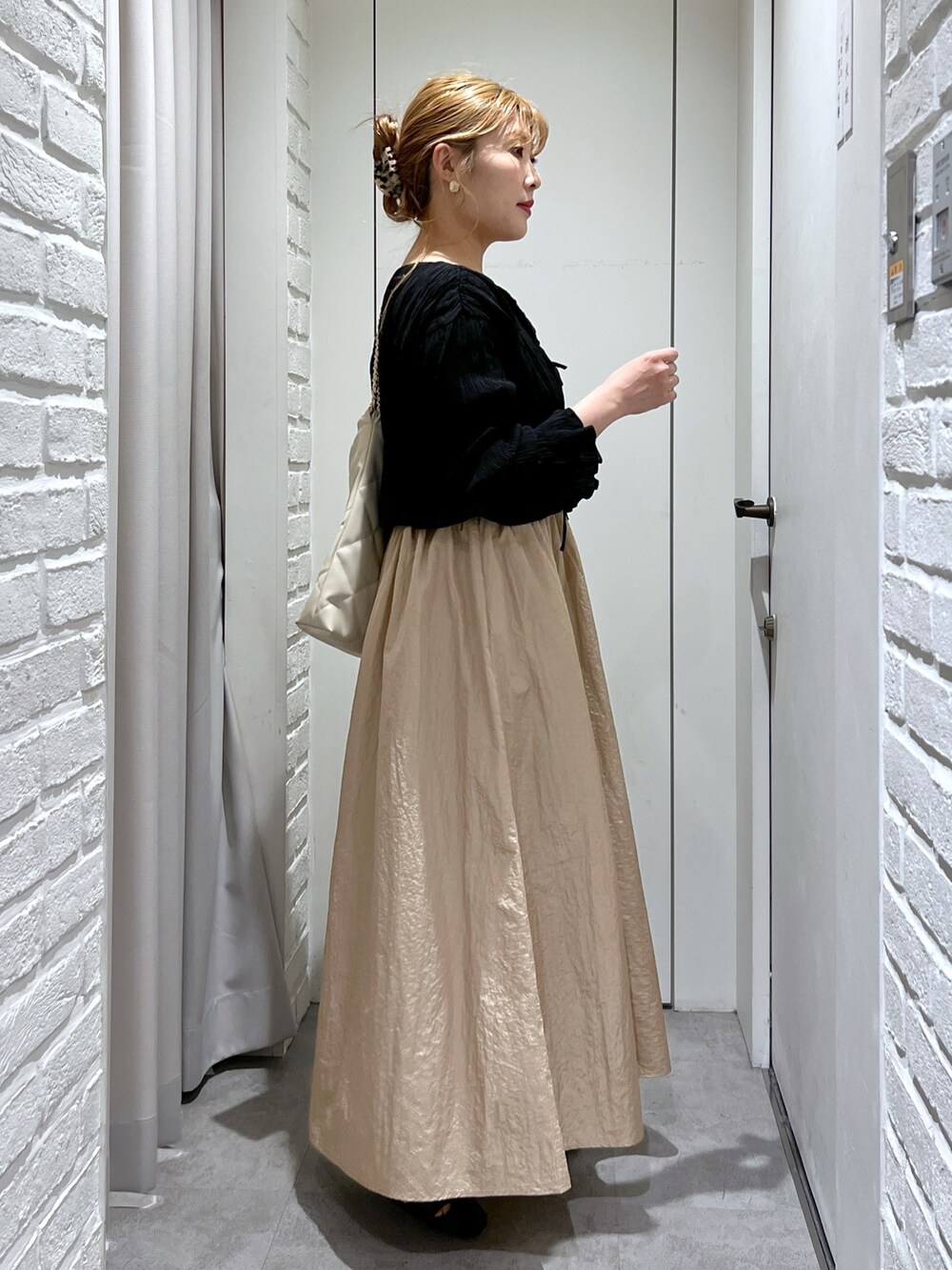 ベージュ系のワンピース、ブラック系のシャツ/ブラウス、ホワイト系のキャミソールを着用したレディースの春コーディネートの2枚目の写真