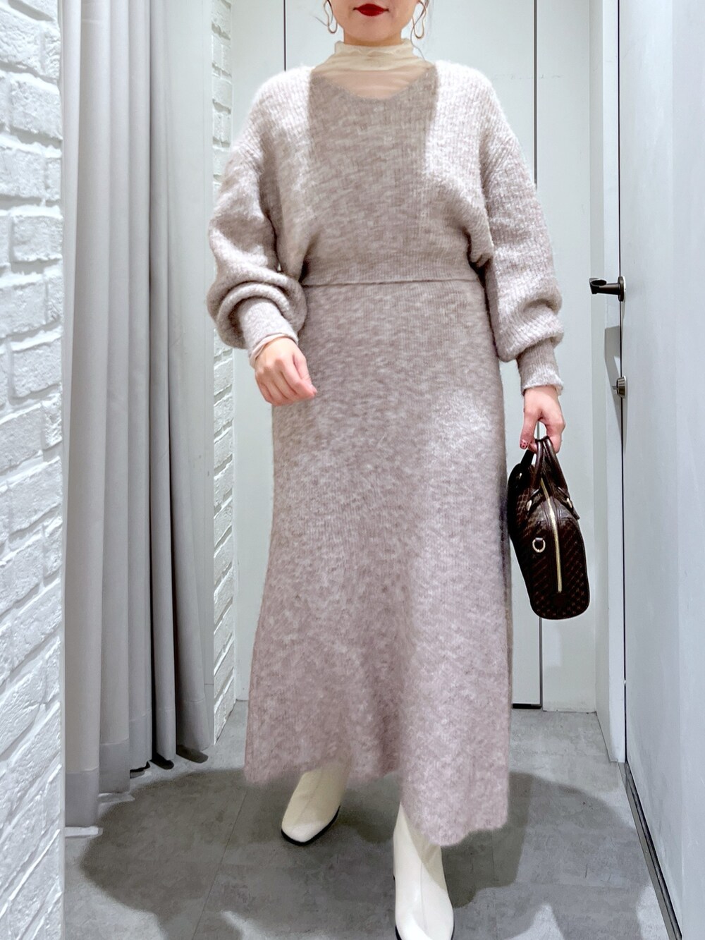 ベージュ系のスカート、ベージュ系のニット/セーター、ベージュ系のバッグを着用したレディースの冬コーディネートの5枚目の写真