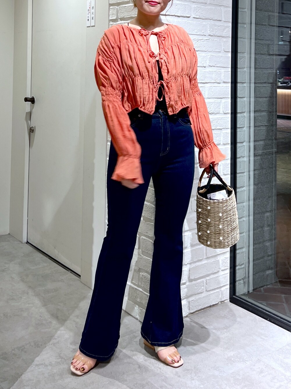 ブルー系のデニムパンツ、オレンジ系のシャツ/ブラウス、グレー系のサンダルを着用したレディースの夏コーディネートの5枚目の写真