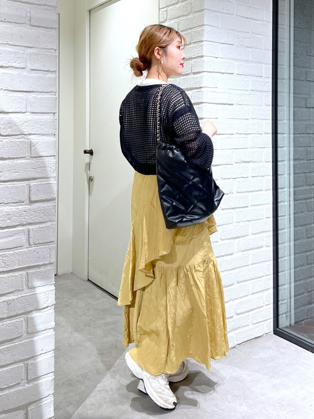 イエロー系のスカート、ブラック系のカーディガン/ボレロ、ホワイト系のTシャツ/カットソーを着用したレディースの夏コーディネートの6枚目の写真