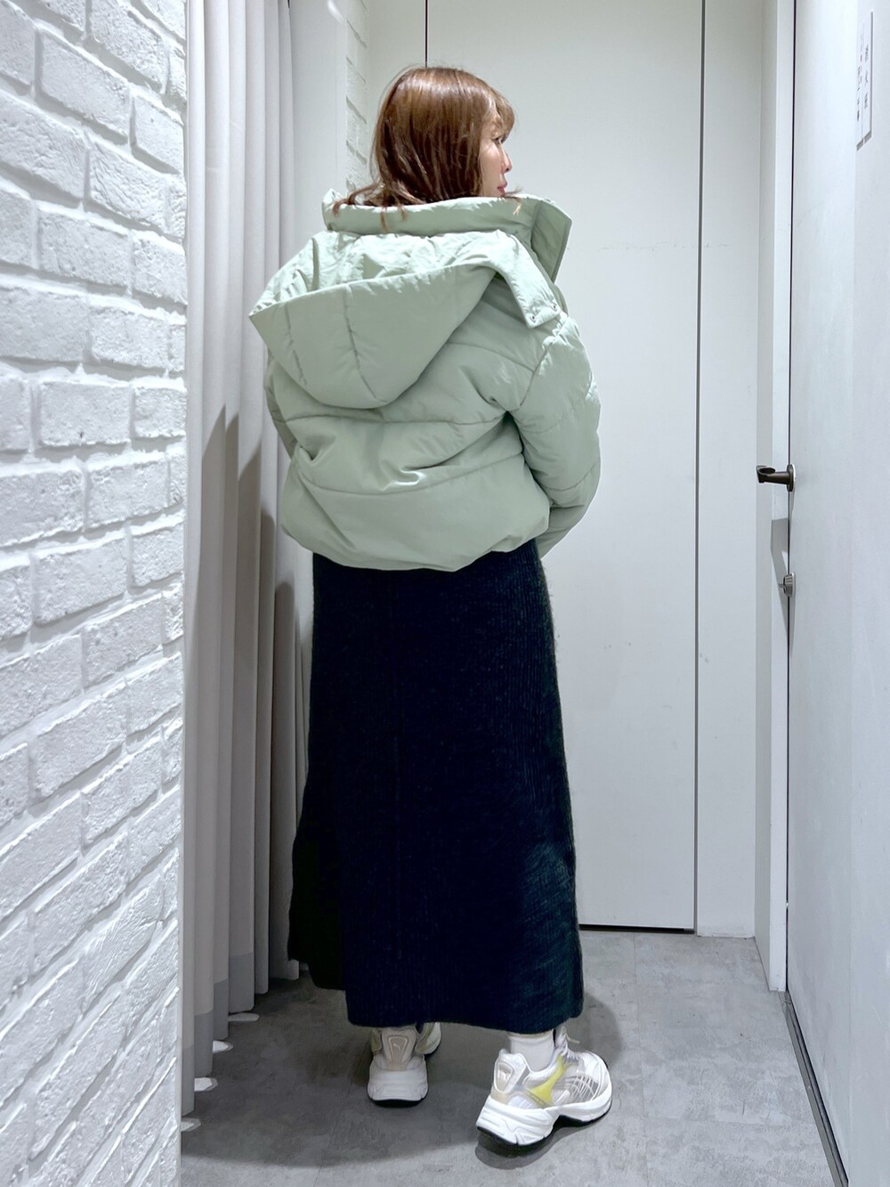 ブラック系のワンピース、グリーン系のブルゾン、ブラック系のショルダーバッグを着用したレディースの冬コーディネートの3枚目の写真