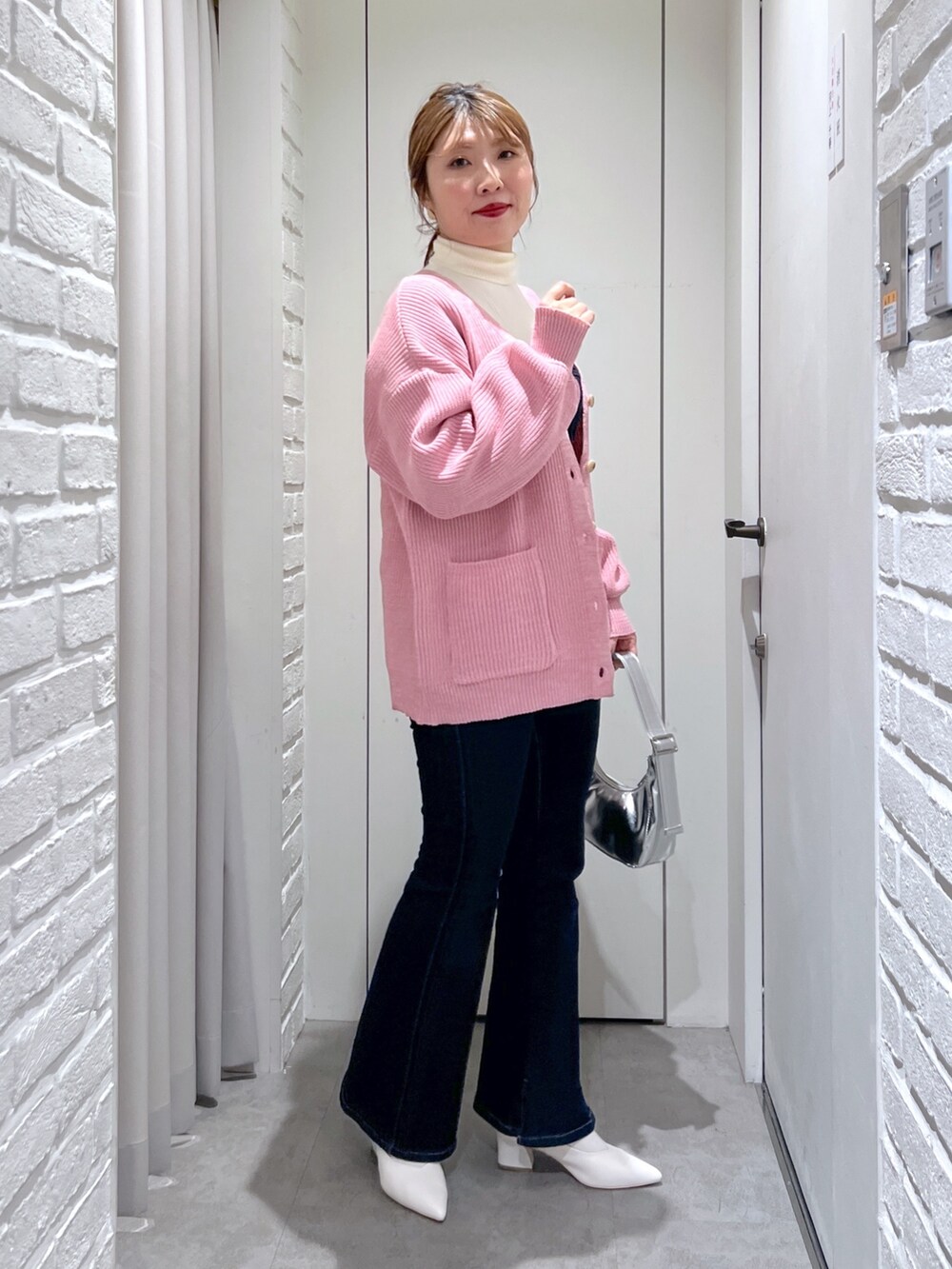 ブルー系のデニムパンツ、ホワイト系のパンプス、ブルー系のベストを着用したレディースの冬コーディネートの2枚目の写真