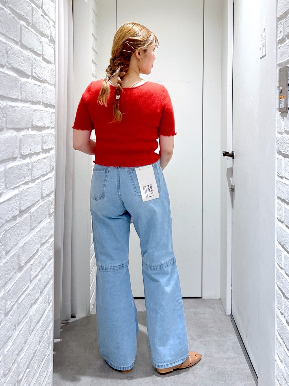 レッド系のニット/セーター、ブルー系のデニムパンツ、ベージュ系のスリッポンを着用したレディースの夏コーディネートの5枚目の写真