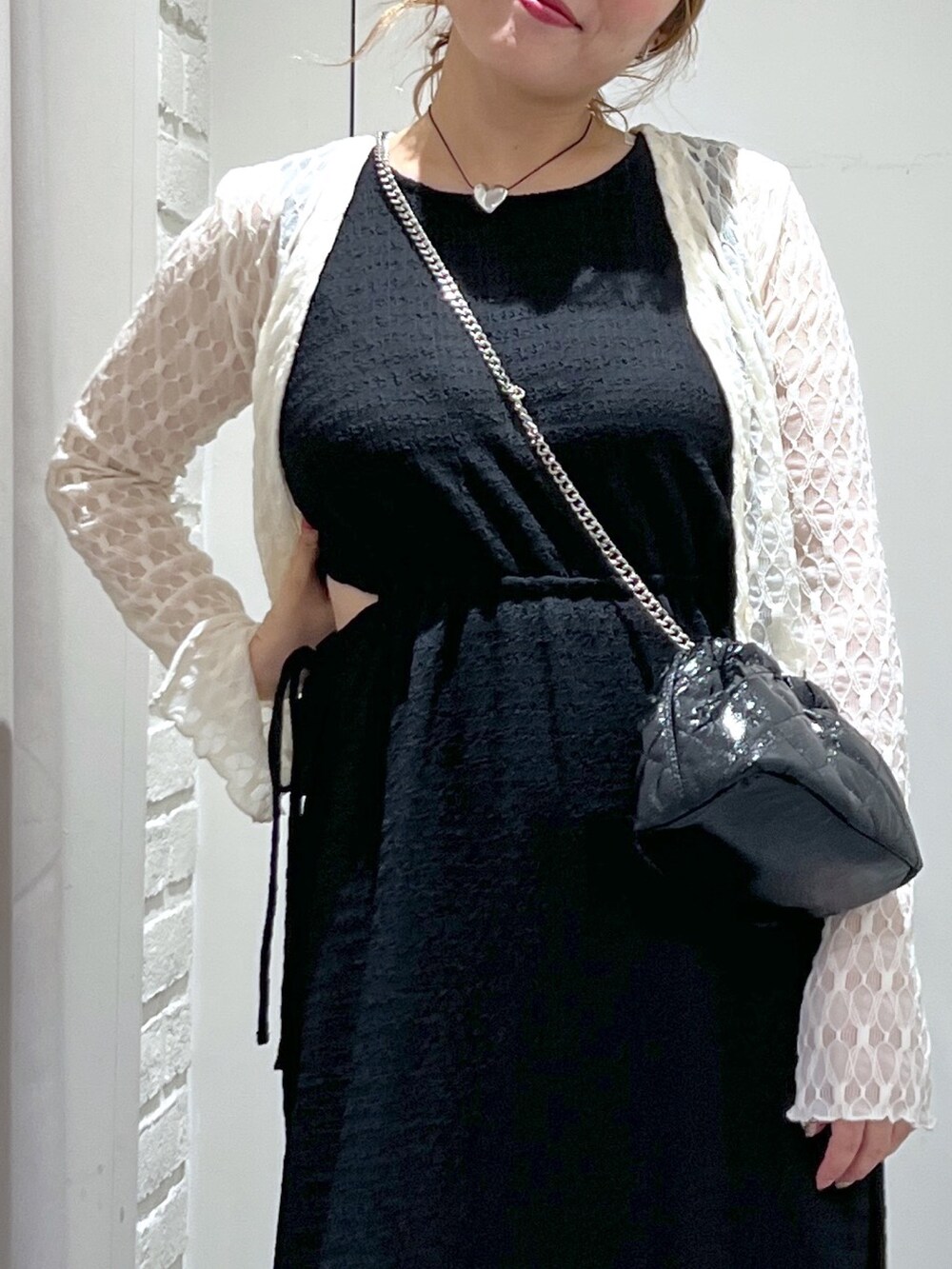 ブラック系のワンピース、ホワイト系のカーディガン/ボレロ、ホワイト系のサンダルを着用したレディースの夏コーディネートの9枚目の写真