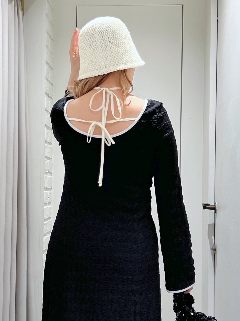 ブラック系のワンピース、ブルー系のデニムパンツ、ブラック系のハンドバッグを着用したレディースの春コーディネートの7枚目の写真