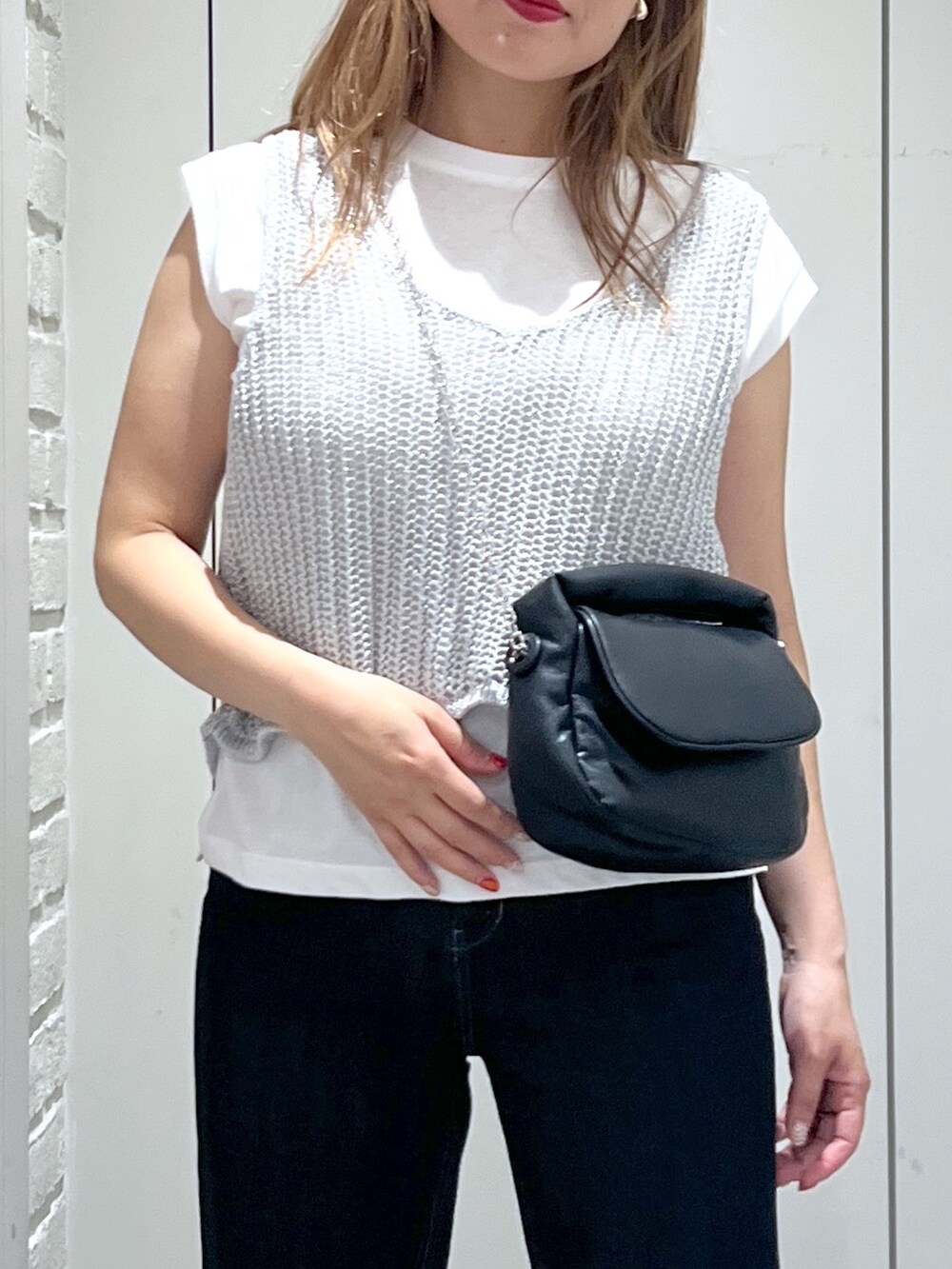 シルバー系のベスト、ブルー系のデニムパンツ、ピンク系のサンダルを着用したレディースの夏コーディネートの7枚目の写真