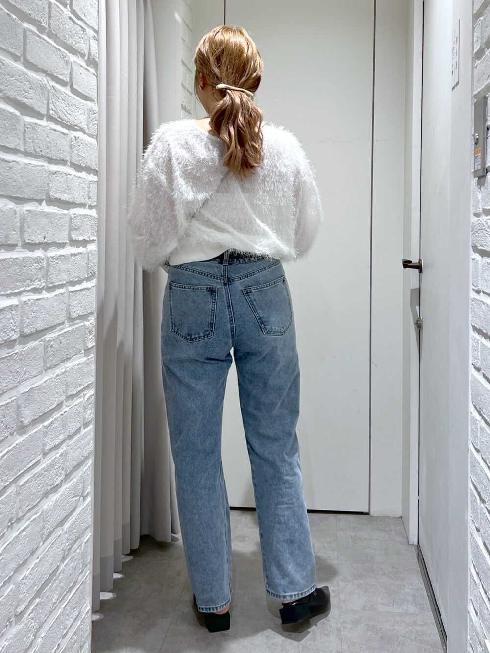 ブルー系のデニムパンツ、ホワイト系のシャツ/ブラウス、シルバー系のショルダーバッグを着用したレディースの春コーディネートの4枚目の写真