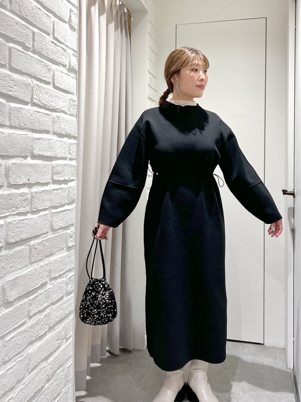 ブラック系のワンピース、ホワイト系のTシャツ/カットソー、ブラック系のハンドバッグを着用したレディースの秋コーディネートの3枚目の写真