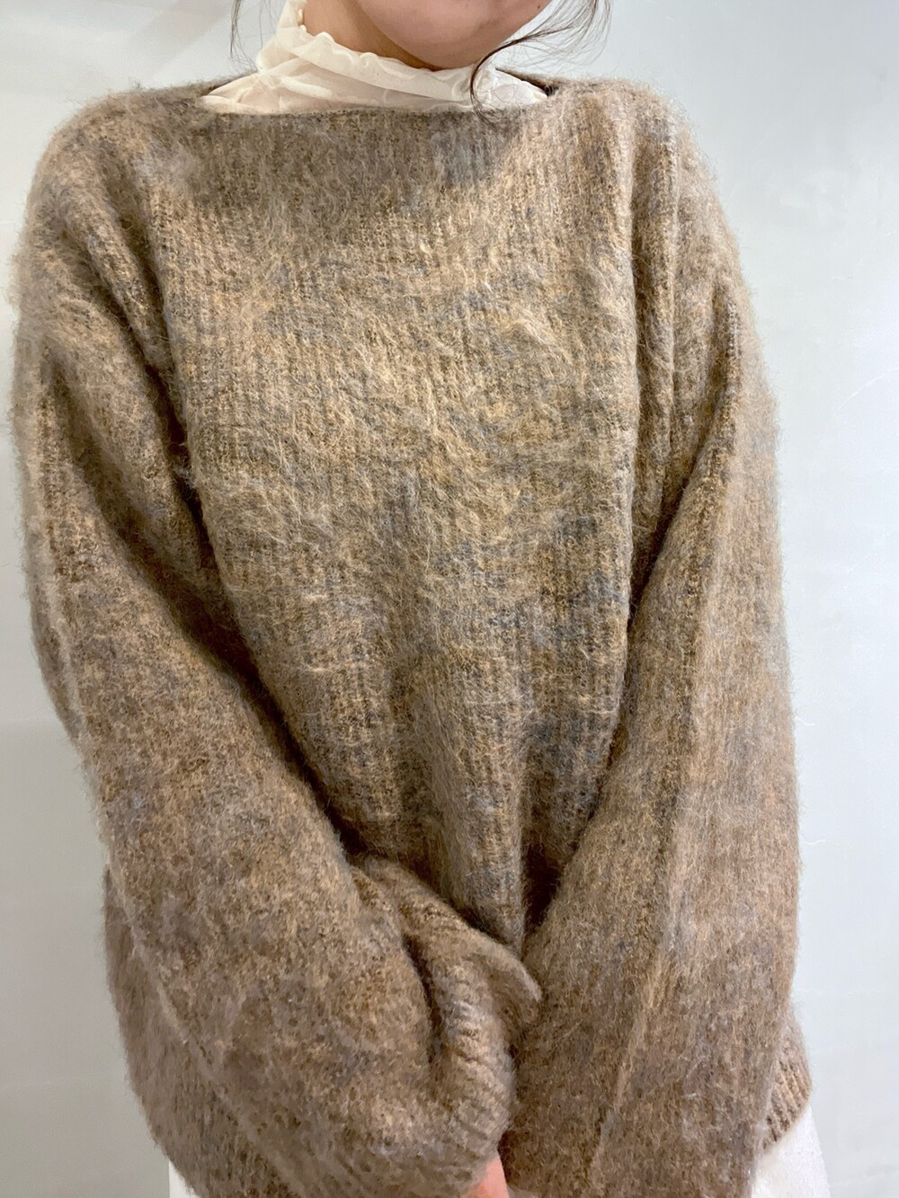 ベージュ系のニット/セーター、ホワイト系のスラックス、ホワイト系のショルダーバッグを着用したレディースの冬コーディネートの7枚目の写真