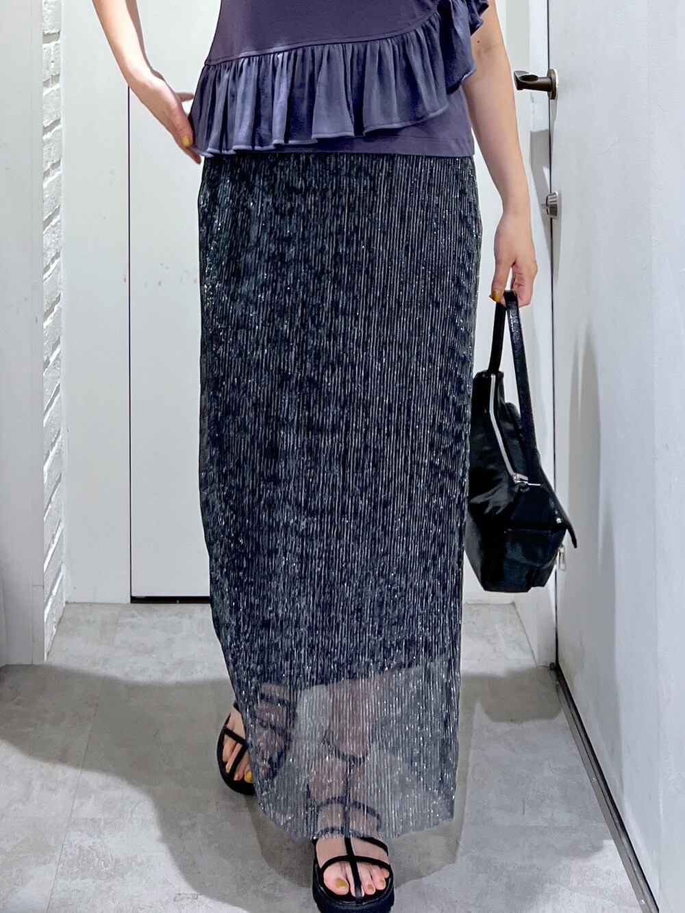 ブラック系のスカート、グレー系のTシャツ/カットソー、ブラック系のサンダルを着用したレディースの夏コーディネートの9枚目の写真