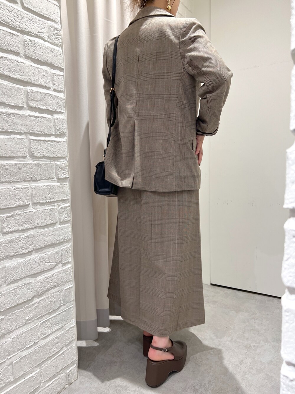 ブラウン系のテーラードジャケット、ブラウン系のワンピース、ブラウン系のサンダルを着用したレディースの秋コーディネートの2枚目の写真