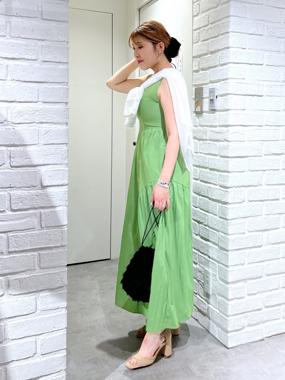 グリーン系のワンピース、ホワイト系のシャツ/ブラウス、ブラック系のハンドバッグを着用したレディースの夏コーディネートの2枚目の写真