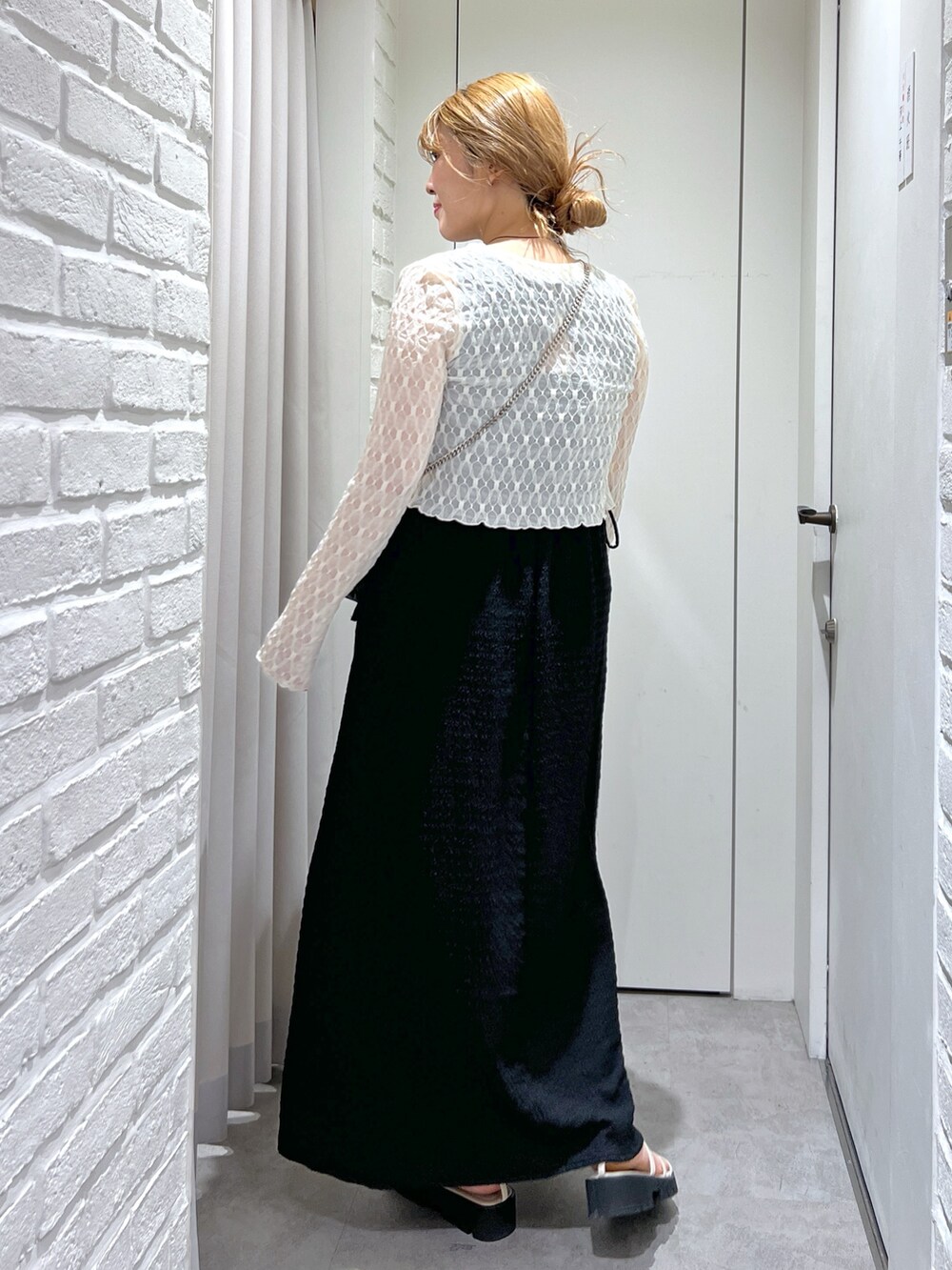 ブラック系のワンピース、ホワイト系のカーディガン/ボレロ、ホワイト系のサンダルを着用したレディースの夏コーディネートの7枚目の写真