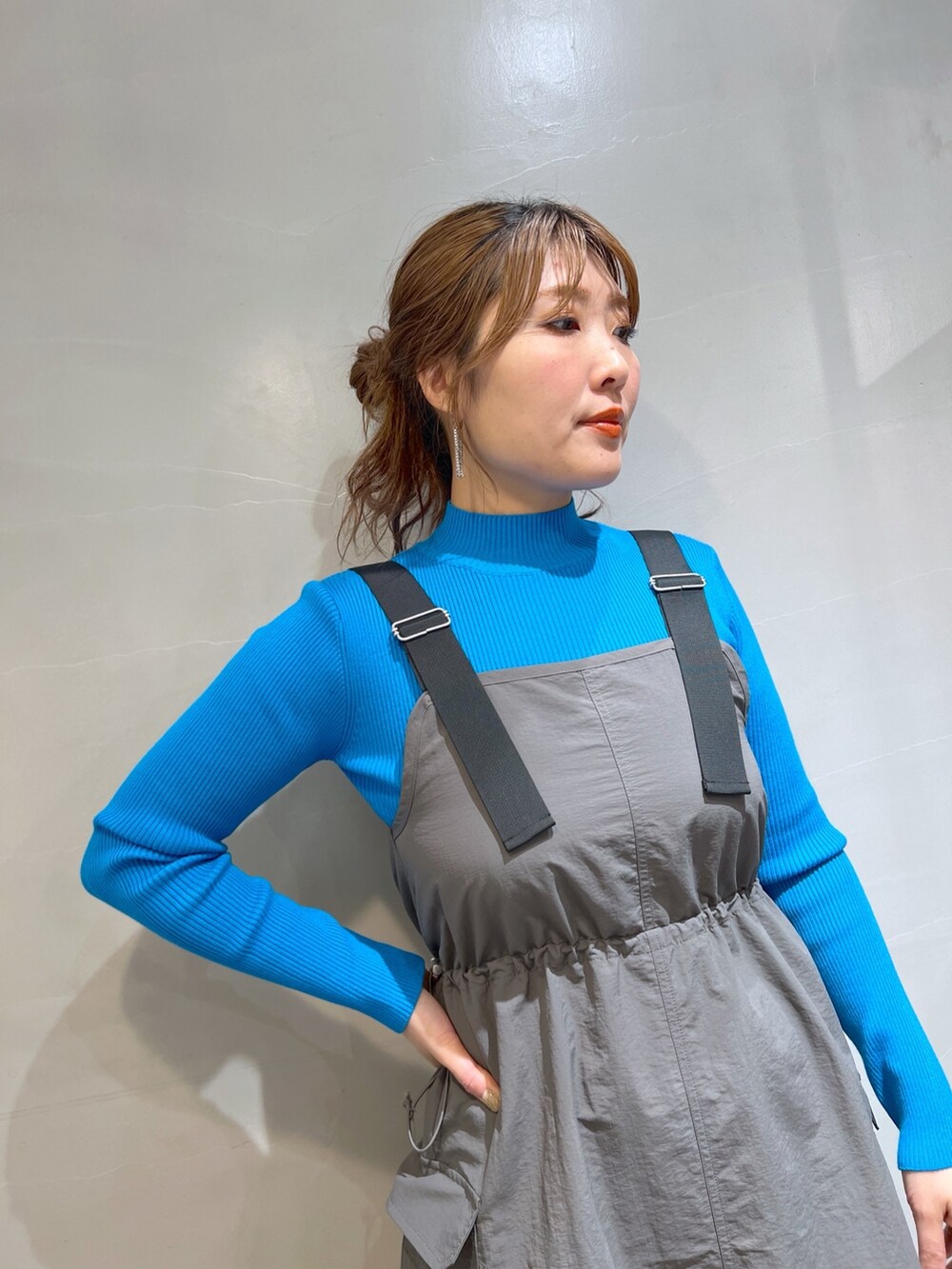 グレー系のワンピース、ブラック系のハンドバッグ、ブラック系のブーツを着用したレディースの冬コーディネートの7枚目の写真