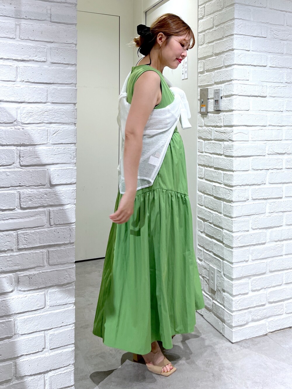 グリーン系のワンピース、ホワイト系のシャツ/ブラウス、ブラック系のハンドバッグを着用したレディースの夏コーディネートの4枚目の写真