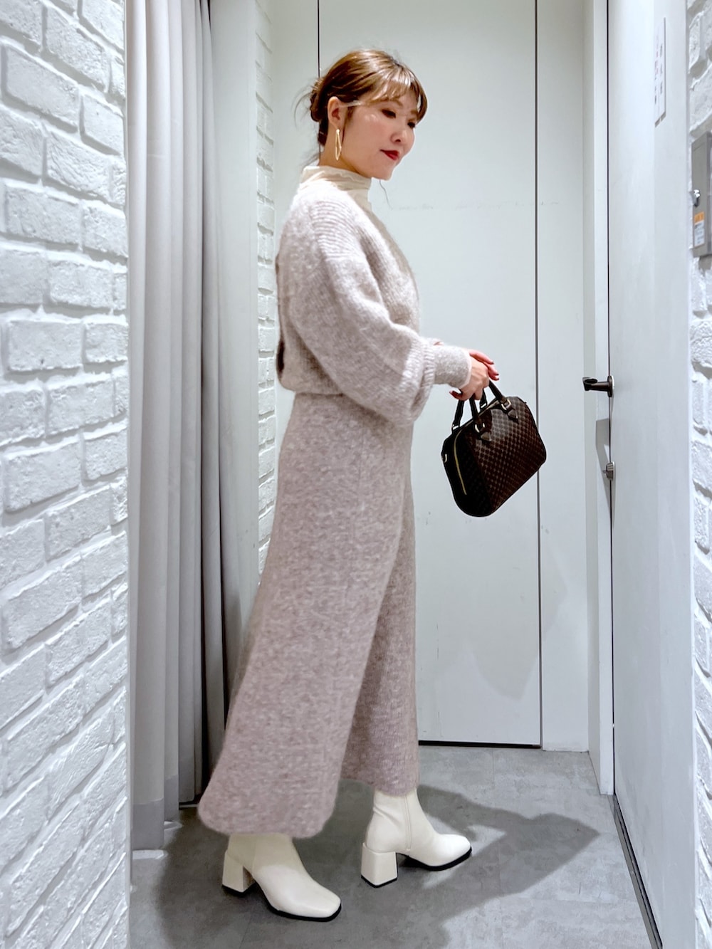 ベージュ系のスカート、ベージュ系のニット/セーター、ベージュ系のバッグを着用したレディースの冬コーディネートの3枚目の写真