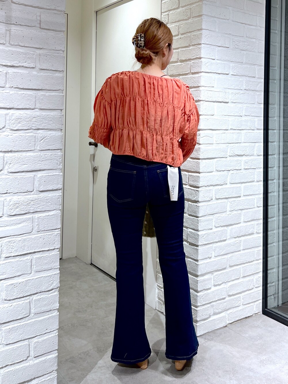 ブルー系のデニムパンツ、オレンジ系のシャツ/ブラウス、グレー系のサンダルを着用したレディースの夏コーディネートの4枚目の写真