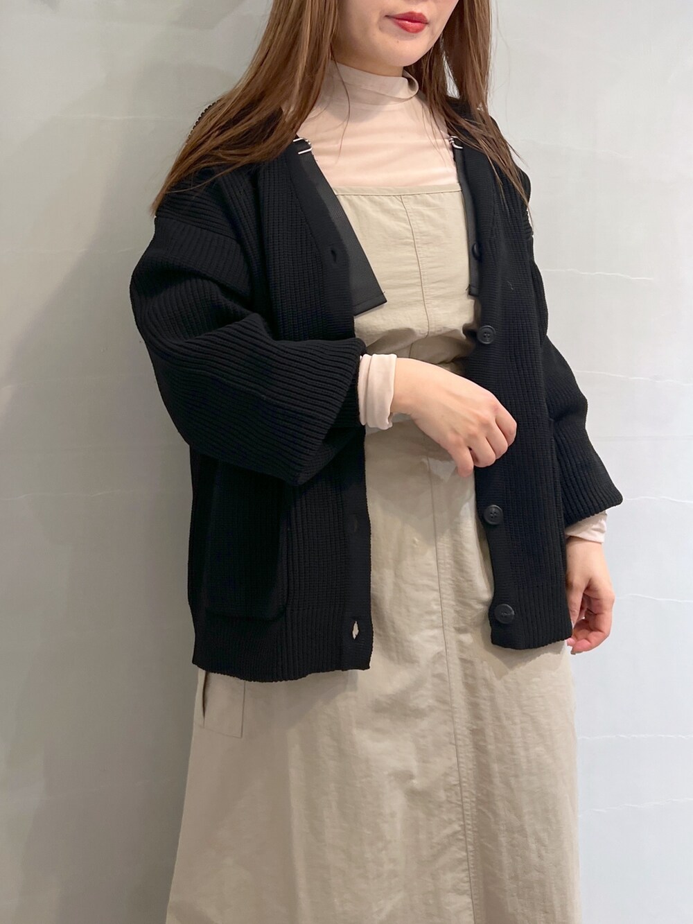 ベージュ系のワンピース、ブラック系のトートバッグ、ブラック系のカーディガン/ボレロを着用したレディースの冬コーディネートの7枚目の写真