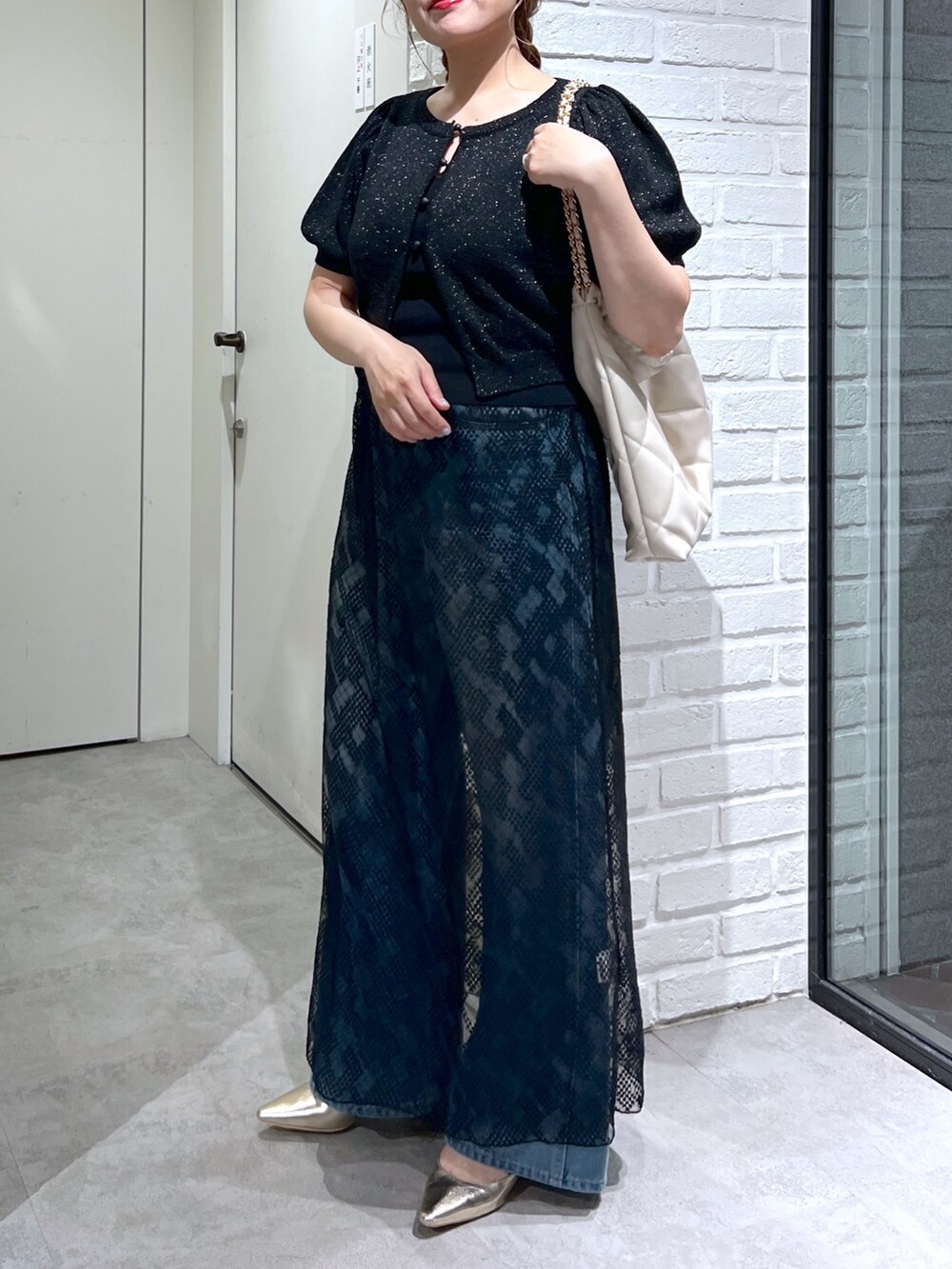 ブラック系のスカート、ブルー系のデニムパンツ、ブラック系のカーディガン/ボレロを着用したレディースの夏コーディネートの6枚目の写真