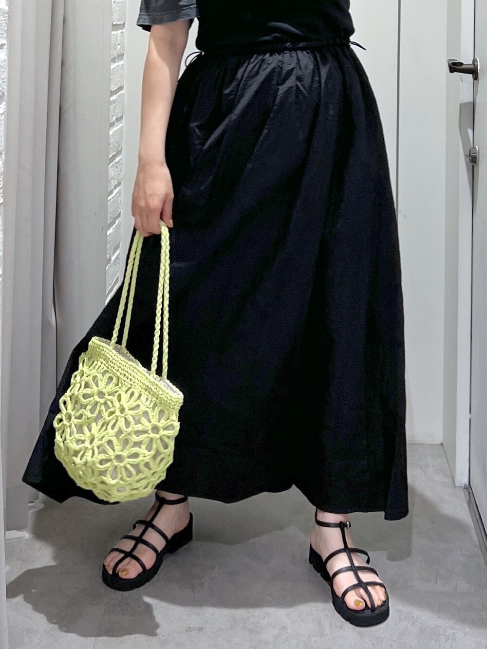 ブラック系のワンピース、ブラック系のTシャツ/カットソー、グリーン系のかごバッグを着用したレディースの夏コーディネートの8枚目の写真