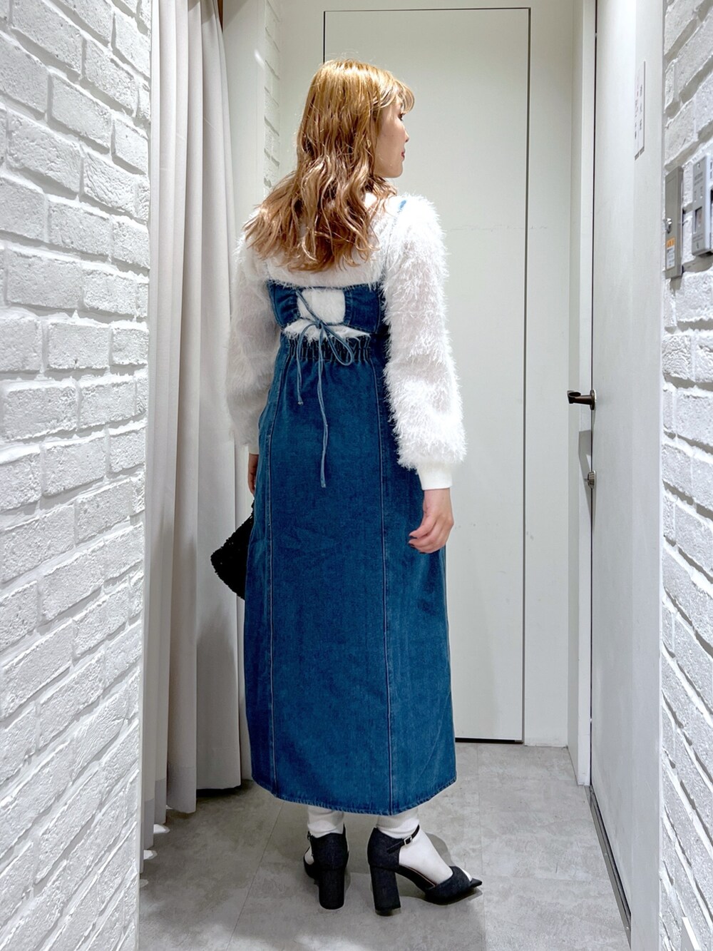 ブルー系のワンピース、ブラック系のサンダル、ブラック系のハンドバッグを着用したレディースの春コーディネートの3枚目の写真