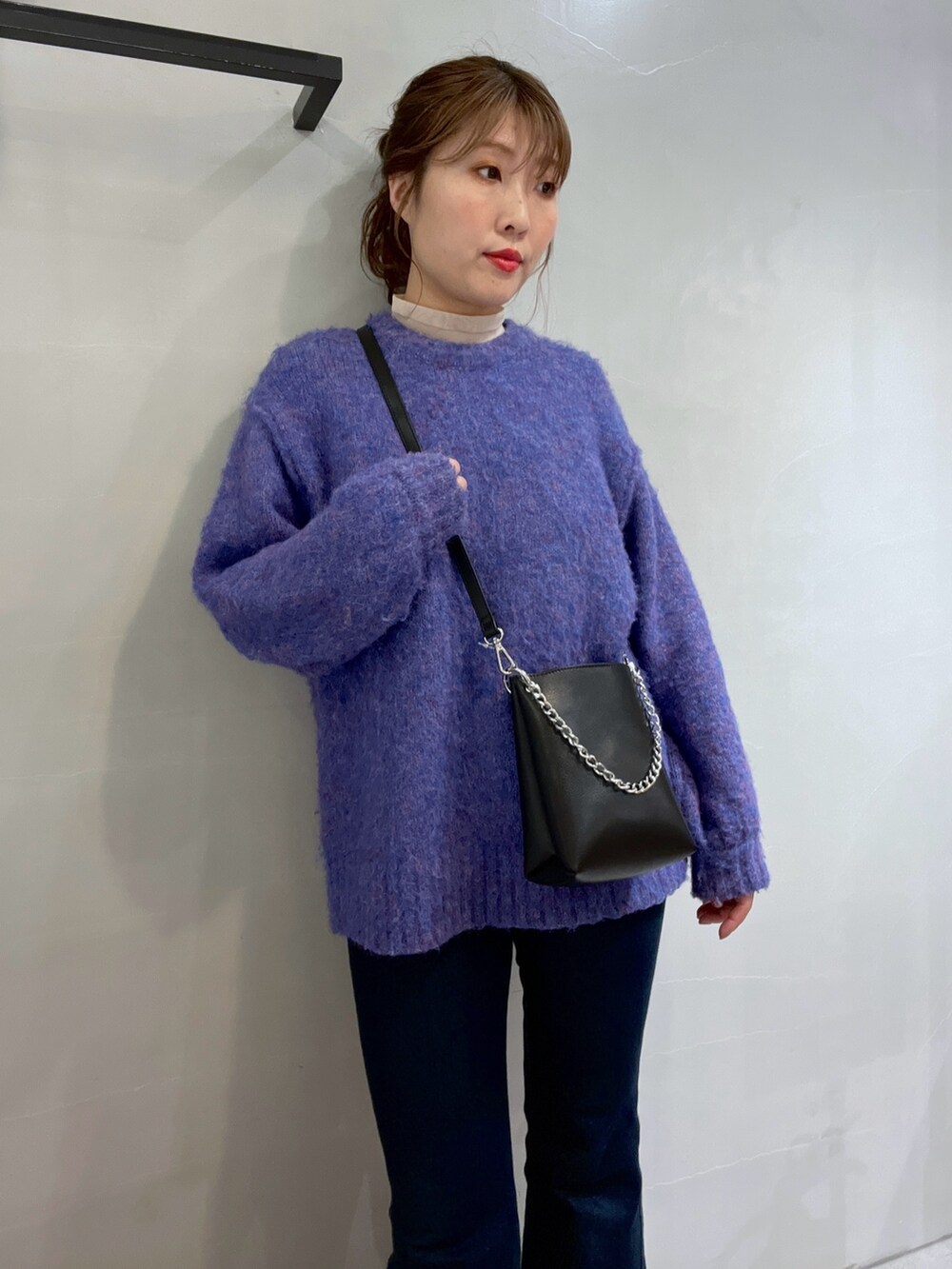 ブルー系のニット/セーター、ブルー系のデニムパンツ、ブラック系のショルダーバッグを着用したレディースの冬コーディネートの6枚目の写真