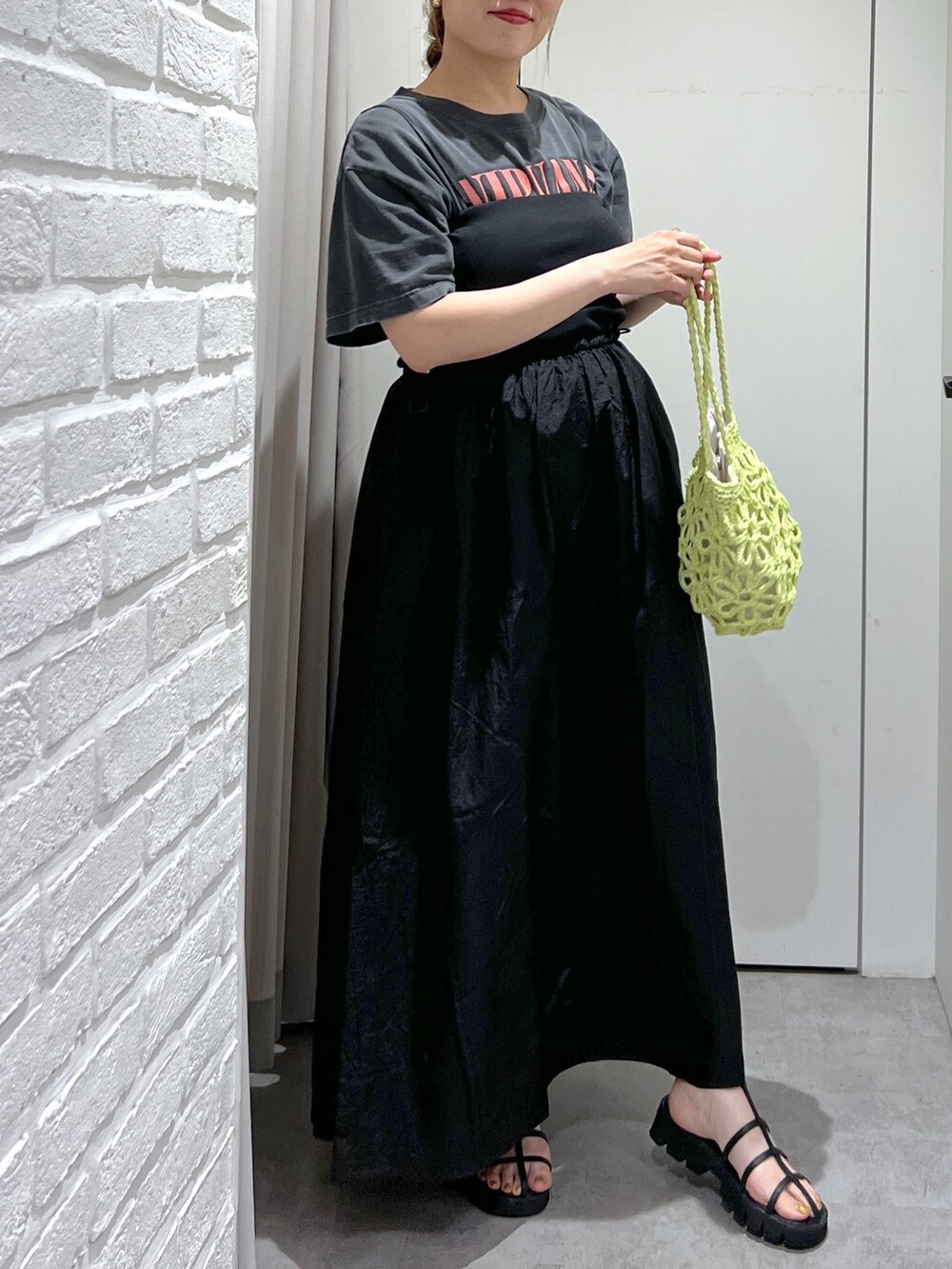 ブラック系のワンピース、ブラック系のTシャツ/カットソー、グリーン系のかごバッグを着用したレディースの夏コーディネートの6枚目の写真