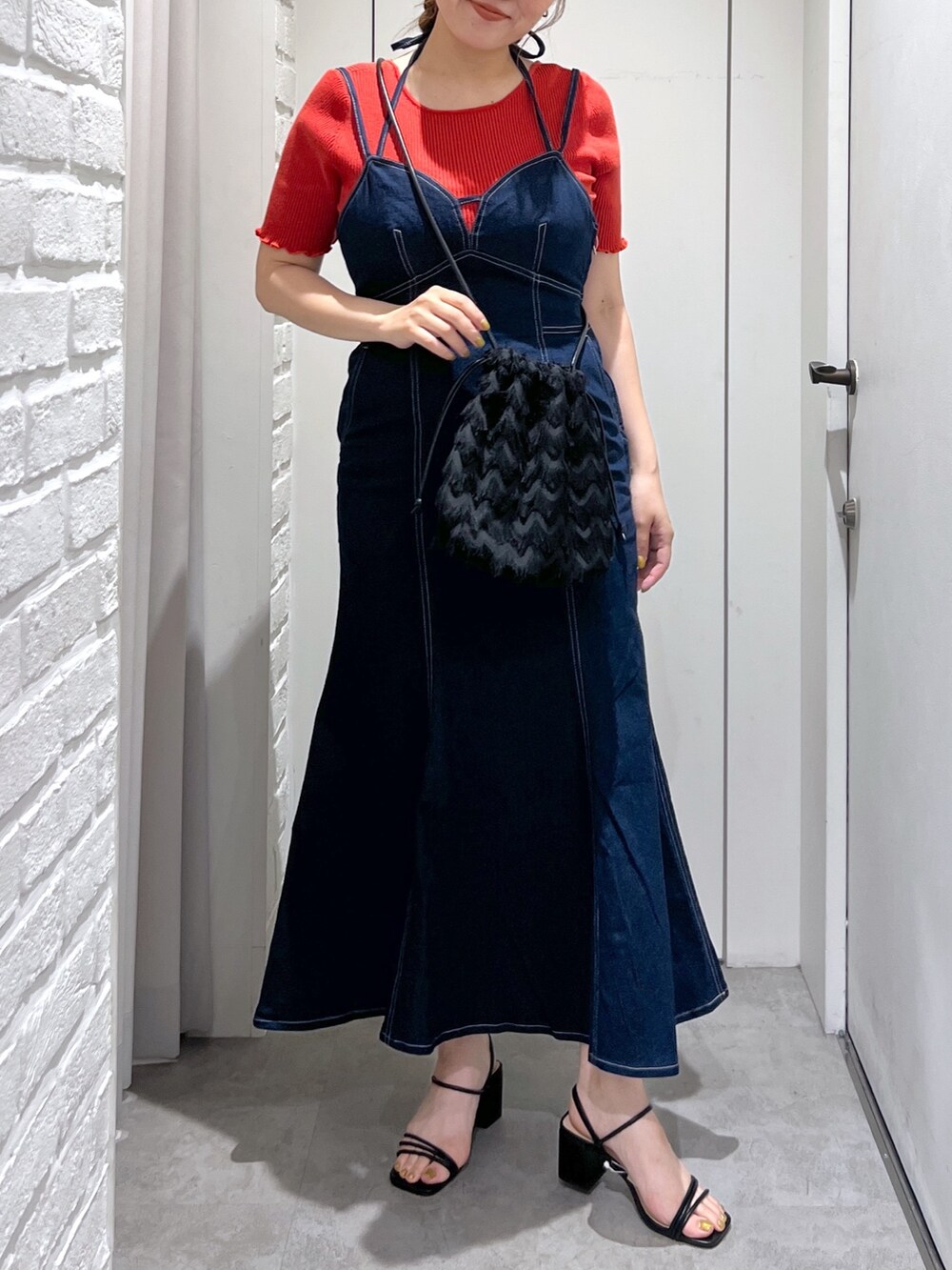 ブラック系のハンドバッグ、ブルー系のワンピース、レッド系のニット/セーターを着用したレディースの夏コーディネートの4枚目の写真