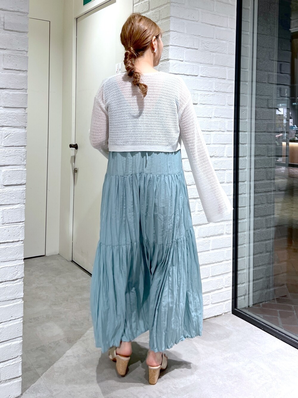 ホワイト系のカーディガン/ボレロ、グリーン系のワンピース、グレー系のサンダルを着用したレディースの夏コーディネートの4枚目の写真