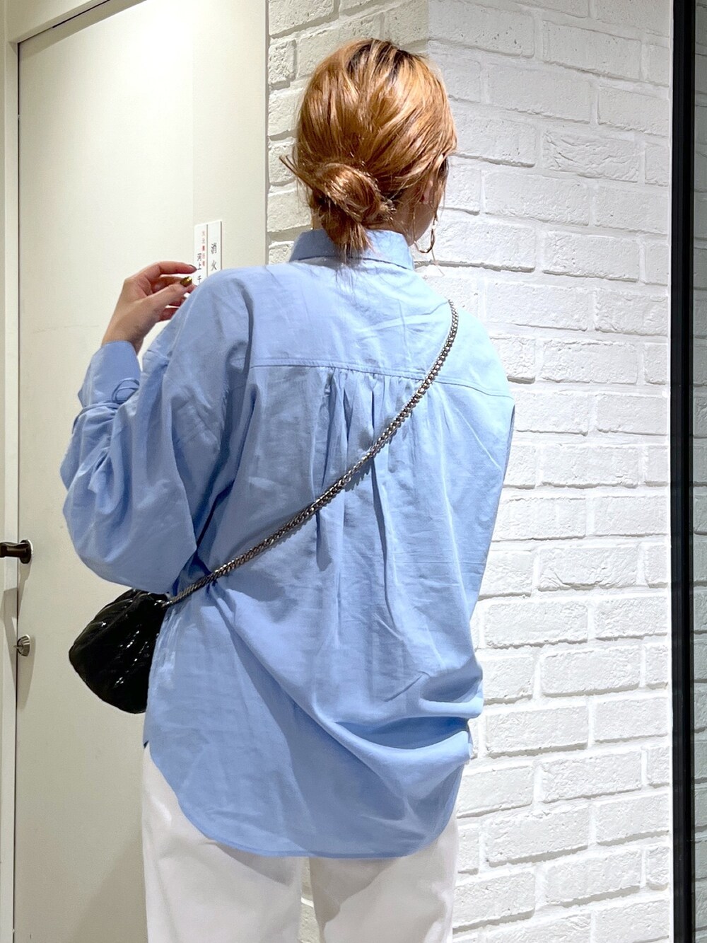 ブルー系のシャツ/ブラウス、ブラック系のショルダーバッグ、ホワイト系のデニムパンツを着用したレディースの夏コーディネートの7枚目の写真